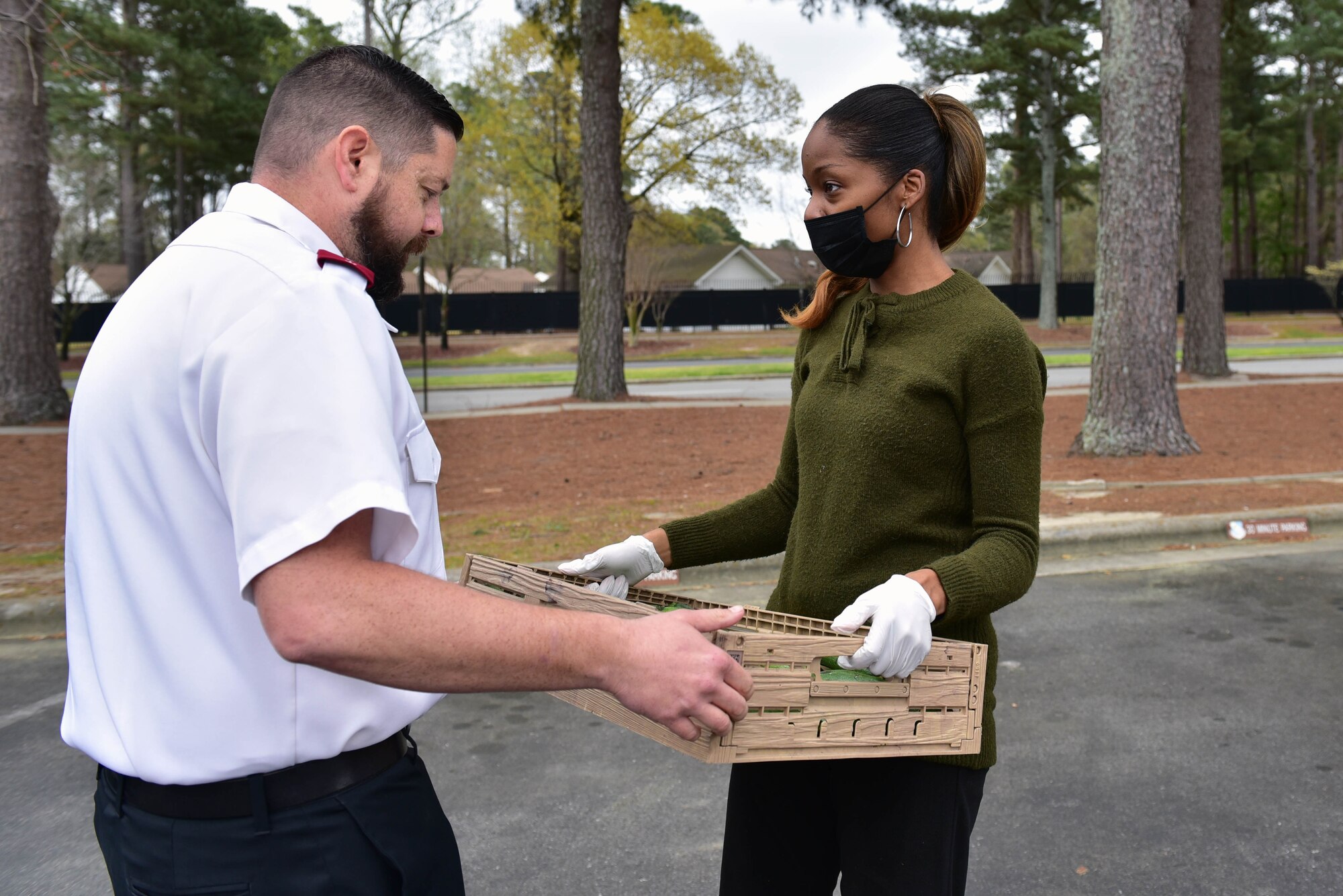 Captain Phillip Stokes, Salvation Army of Goldsboro corps officer, left, accepts donated produce from Melanie Simon at Seymour Johnson Air Force Base, N.C. on March 22, 2020.
