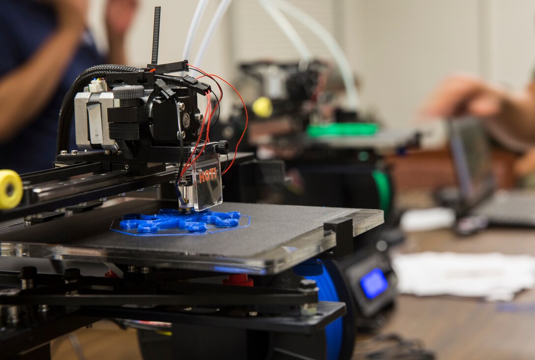 A 3D printer manufactures a plastic part.