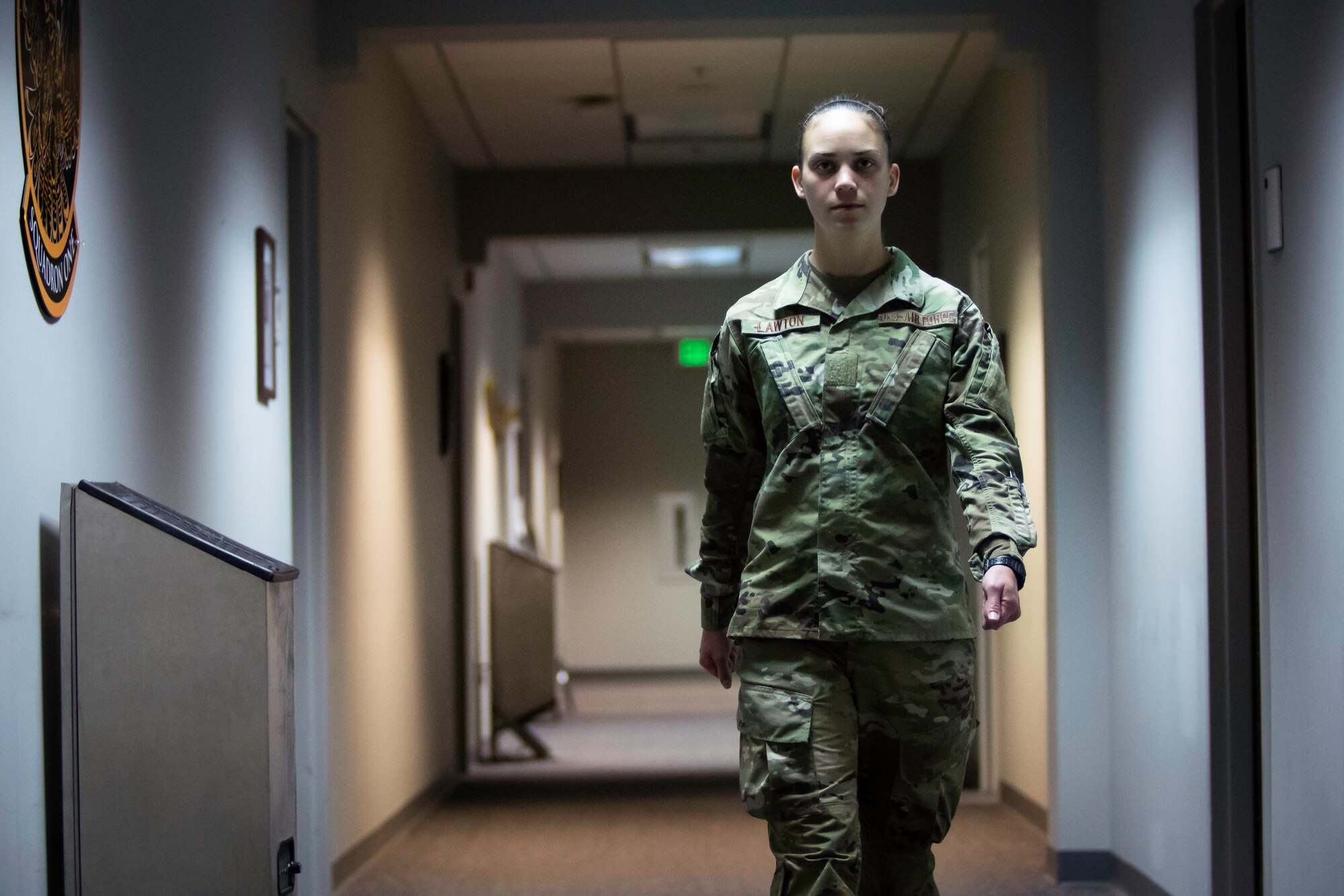 An OTS trainee walks down a hallway.