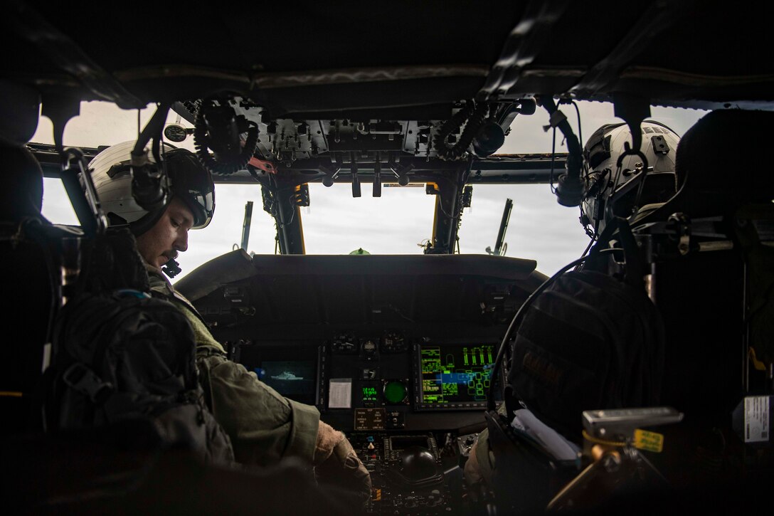 U.S. Navy pilots fly a helicopter.