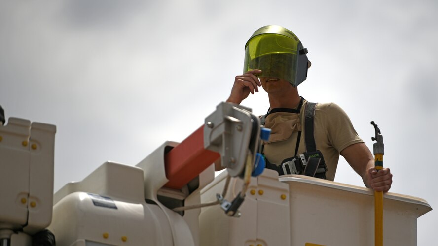 Photo of a electrical systems shop Airman stands in a truck manlift before performing emergency electrical maintenance