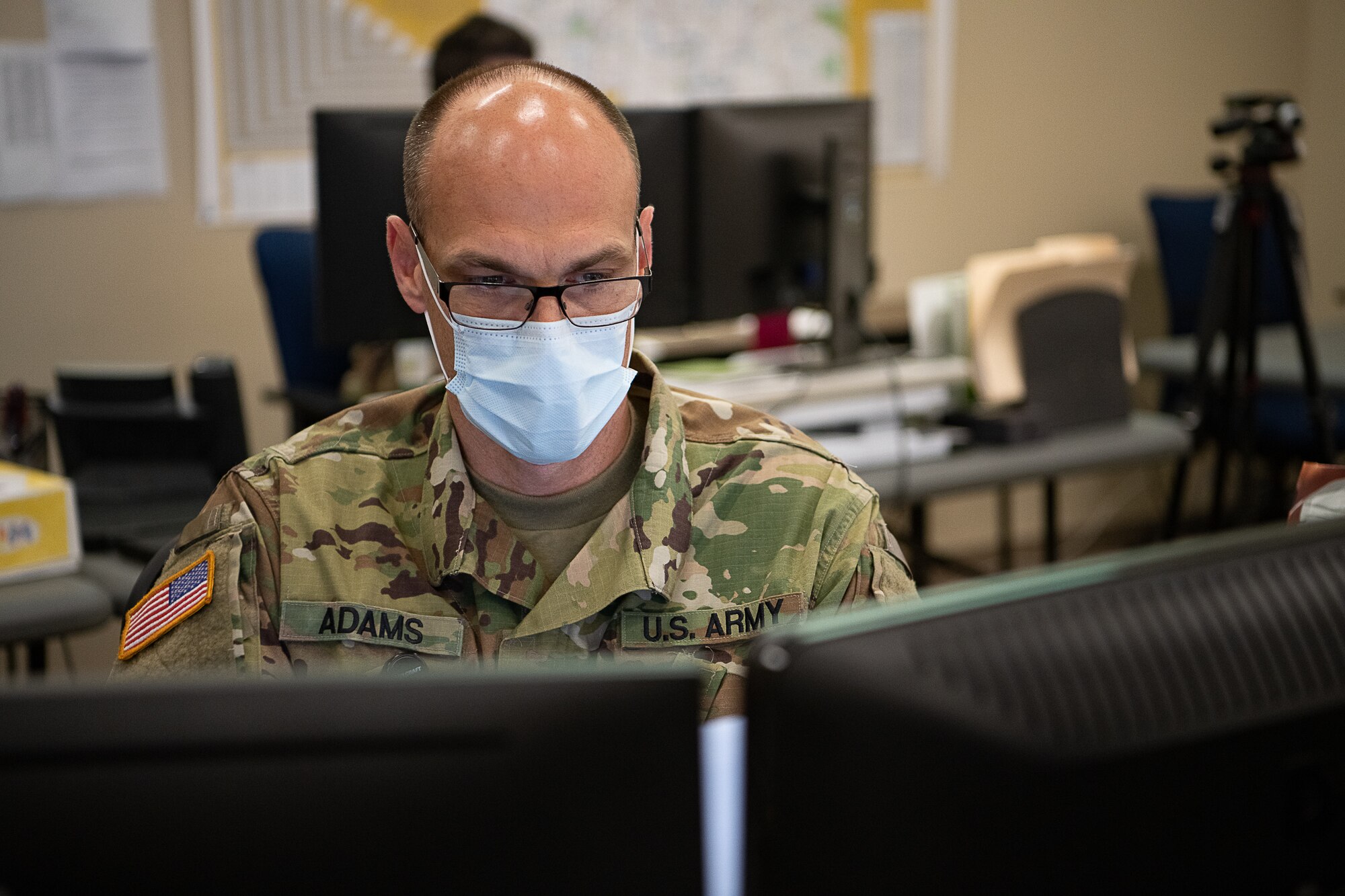 Oklahoma Army National Guard Sergeant 1st Class Michael Adams, senior operations noncommissioned officer assigned to the Oklahoma Joint Task Force, gathers data for current operations reports while working within the Oklahoma Joint Task Force at the Multiagency Coordination Center in Oklahoma City, April 14, 2020. Oklahoma Gov. Kevin Stitt activated 175 additional Oklahoma Army and Air National Guardsmen, April 13, 2020, to aid various missions in support of the state’s response to COVID-19. (U.S. Air National Guard photo by Tech. Sgt. Kasey M. Phipps)