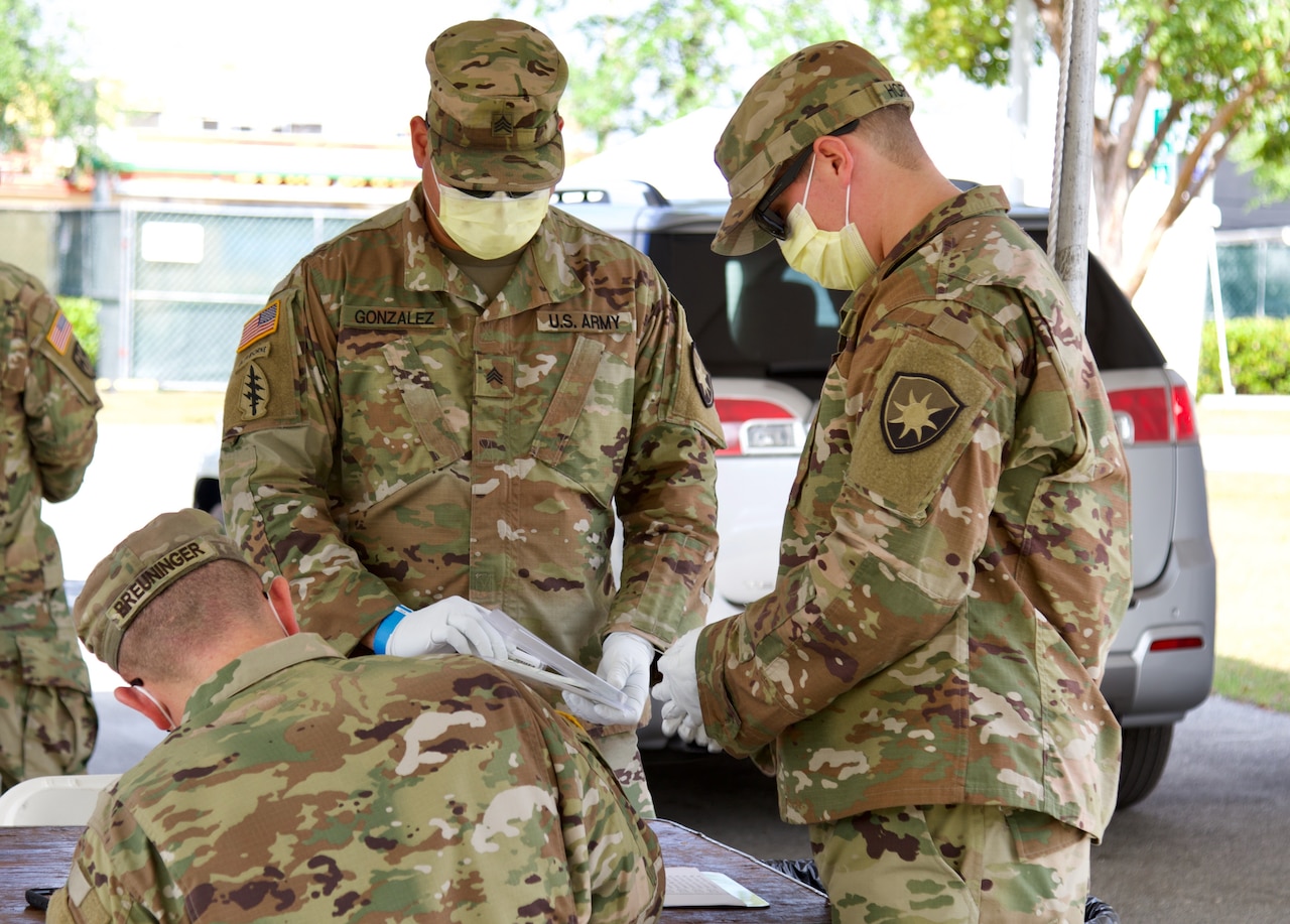 Three National Guard soldiers wear protective equipment.