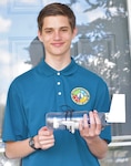 IMAGE: KING GEORGE, Va. – Virginia Commonwealth Governor’s School student Alex Dachos is pictured with the autonomous underwater glider he built over the course of a year via the Naval Surface Warfare Center Dahlgren Division (NSWCDD) SeaGlide Program. Dachos programmed, built, and demonstrated the SeaGlide independently under the guidance of NSWCDD science, technology, engineering and mathematics mentors. The robot collects data through sensors while moving and gliding by changing its pitch and buoyancy, often by taking in or expelling water.  (U.S. Navy photo/Released)