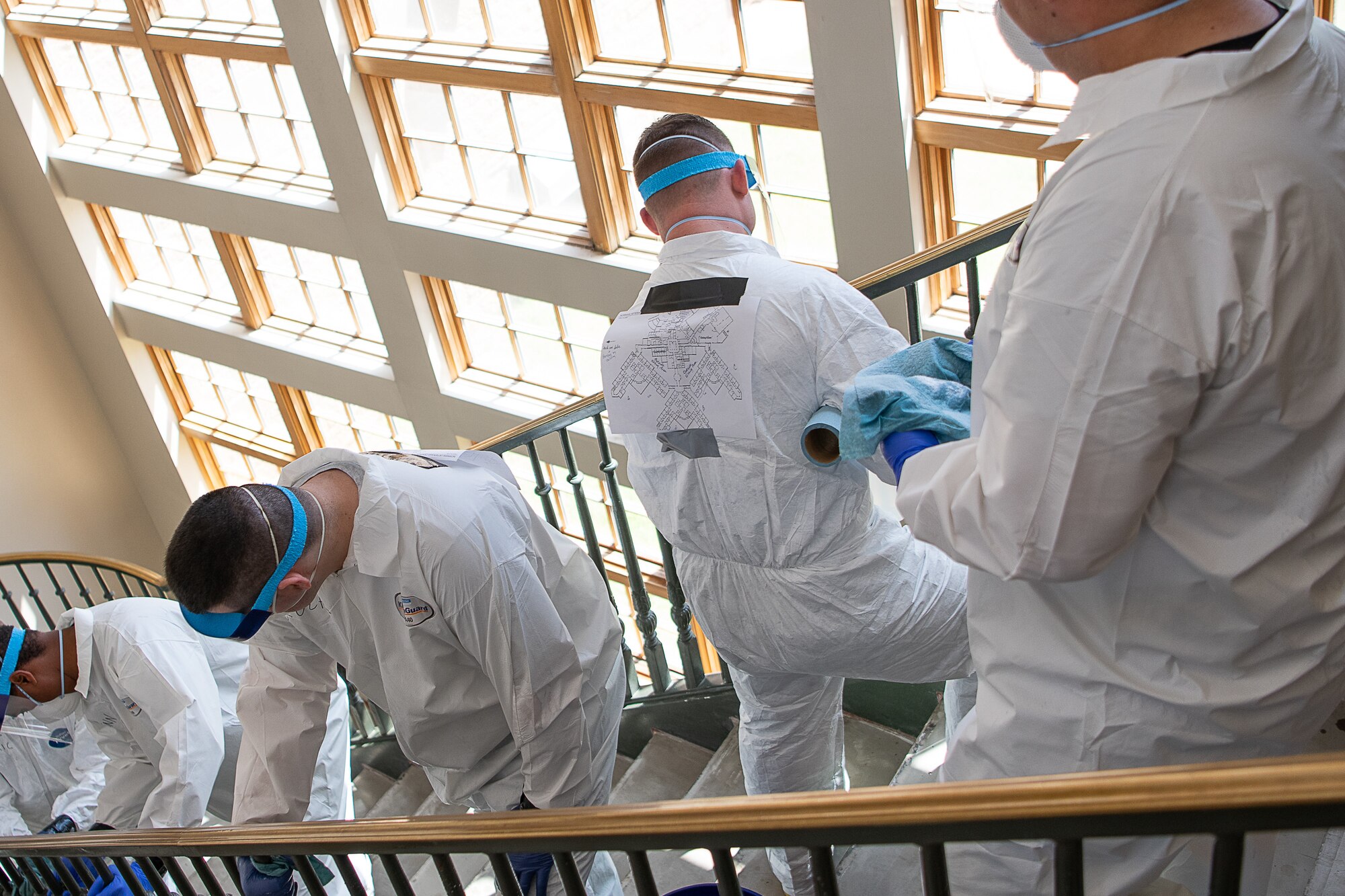 Oklahoma Army and Air National Guardsmen line a stairway as they use Disease Control and Prevention-approved methods to disinfect a stairway of the Norman Veterans Center in Norman, Oklahoma, April 29, 2020. Guardsmen were at the Center to disinfect commonly touched surfaces and high traffic areas including handrails, chair arms, tables, switches and elevator buttons, split up into three teams, in order to more efficiently covering all of the common areas of the 275,000 square-foot facility. Using pressure sprayers and hand sprayers filled with Centers for Disease Control and Prevention-approved disinfectants, the teams worked from the back of the facility to the front. The residents’ military service spans from World War II to Operation Desert Storm. (U.S. Air National Guard photo by Tech. Sgt. Kasey M. Phipps)