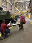 Reginald Fluellen, left, supervisor, Production Plant Albany, Marine Depot Maintenance Command, screens employees as part of a comprehensive plan to safeguard the health and welfare of those returning to the workplace.