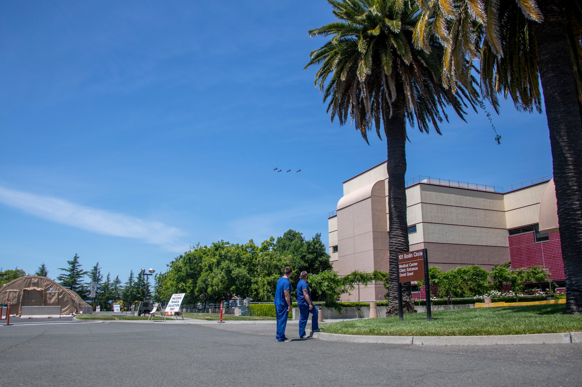 U.S. Airmen watch four T-38A Talons fly over David Grant USAF Medical Center May 9, 2020, at Travis Air Force Base, California. The Operation American Resolve flyover featured four Talons that are assigned to the 9th Reconnaissance Wing at Beale AFB, California, and was conducted to salute healthcare workers and first responders in Northern California impacted by COVID-19. (U.S. Air Force photo by Tech. Sgt. James Hodgman)