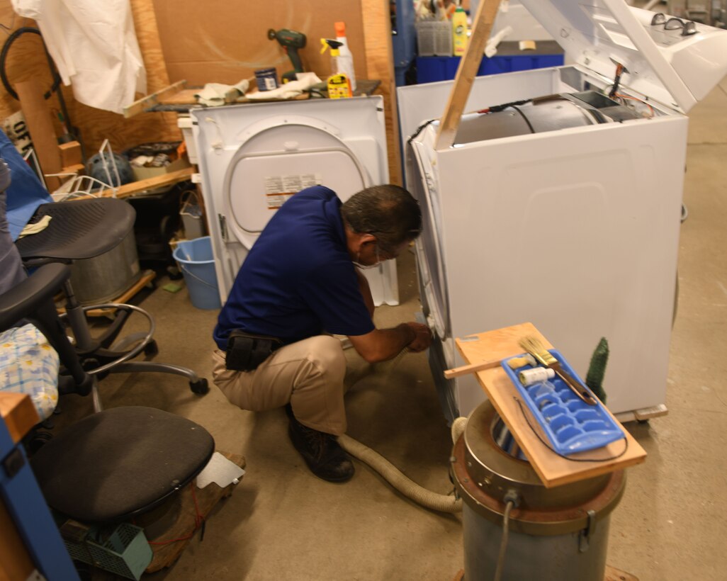 Maintenance man repairing an appliance.