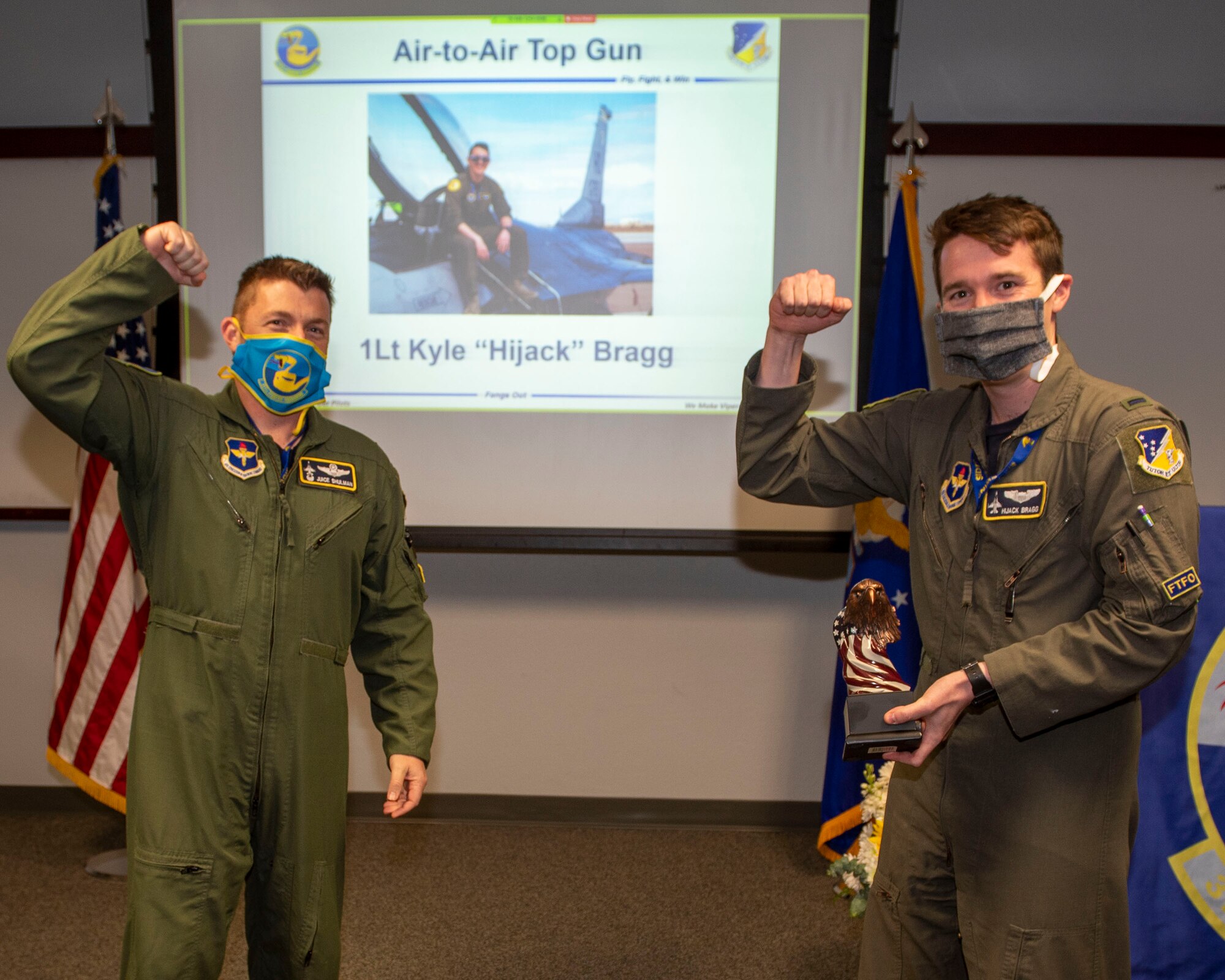 Lt. Col. Jeffrey Shulman, 311th Fighter Squadron commander, presents the Air-to-Air award to 1st Lt. Kyle Bragg, 311th FS Basic Course graduate, during the graduation of B-course Class 19-DBH, May 8, 2020, on Holloman Air Force Base, N.M. Twelve B-course students graduated and will be reassigned to operational flying units throughout the Combat Air Force. (U.S. Air Force photo by Staff Sgt. Christine Groening)