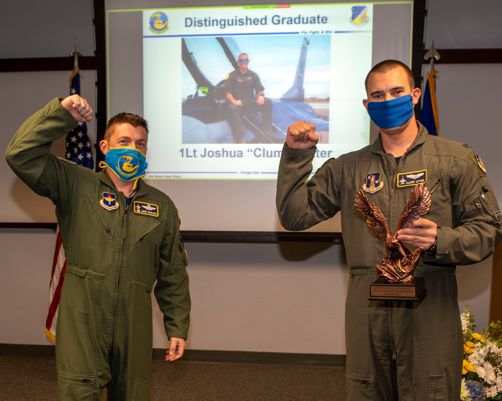 Lt. Col. Jeffrey Shulman, 311th Fighter Squadron commander, presents the Distinguished Graduate award to 1st Lt. Joshua Utter, 311th FS Basic Course graduate, during the graduation of B-course Class 19-DBH, May 8, 2020, on Holloman Air Force Base, N.M. Twelve B-course students graduated and will be reassigned to operational flying units throughout the Combat Air Force. (U.S. Air Force photo by Staff Sgt. Christine Groening)