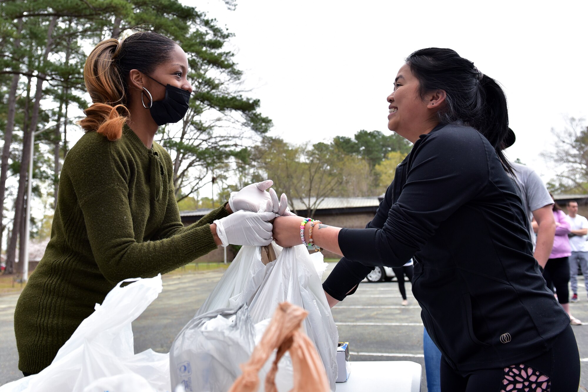 Melanie Simon, left, hands produce to Tina Anderson, during a bi-monthly produce run at Seymour Johnson Air Force Base, N.C. on March 22, 2020.