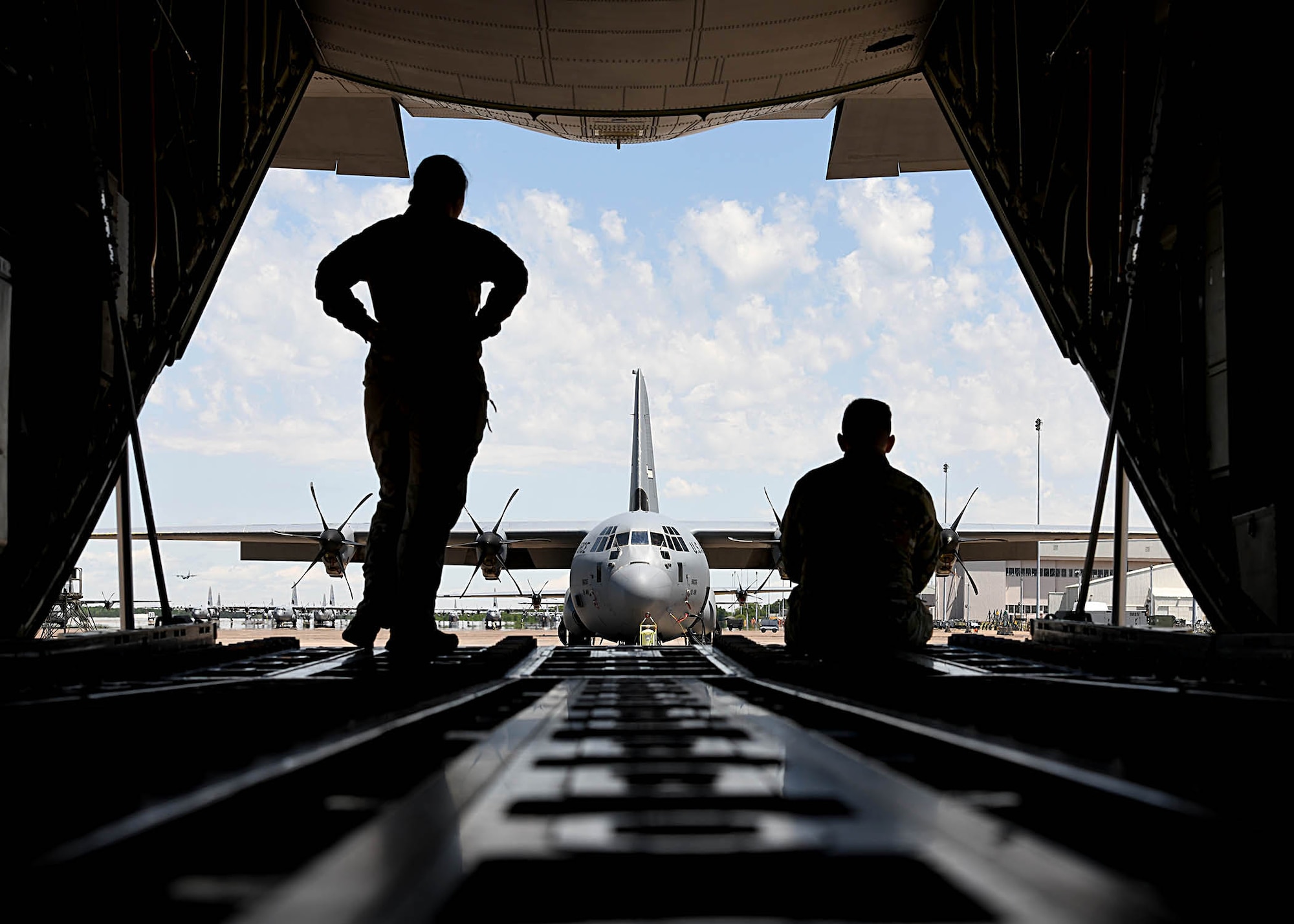 Airmen sit on the ramp of an aircraft before take off