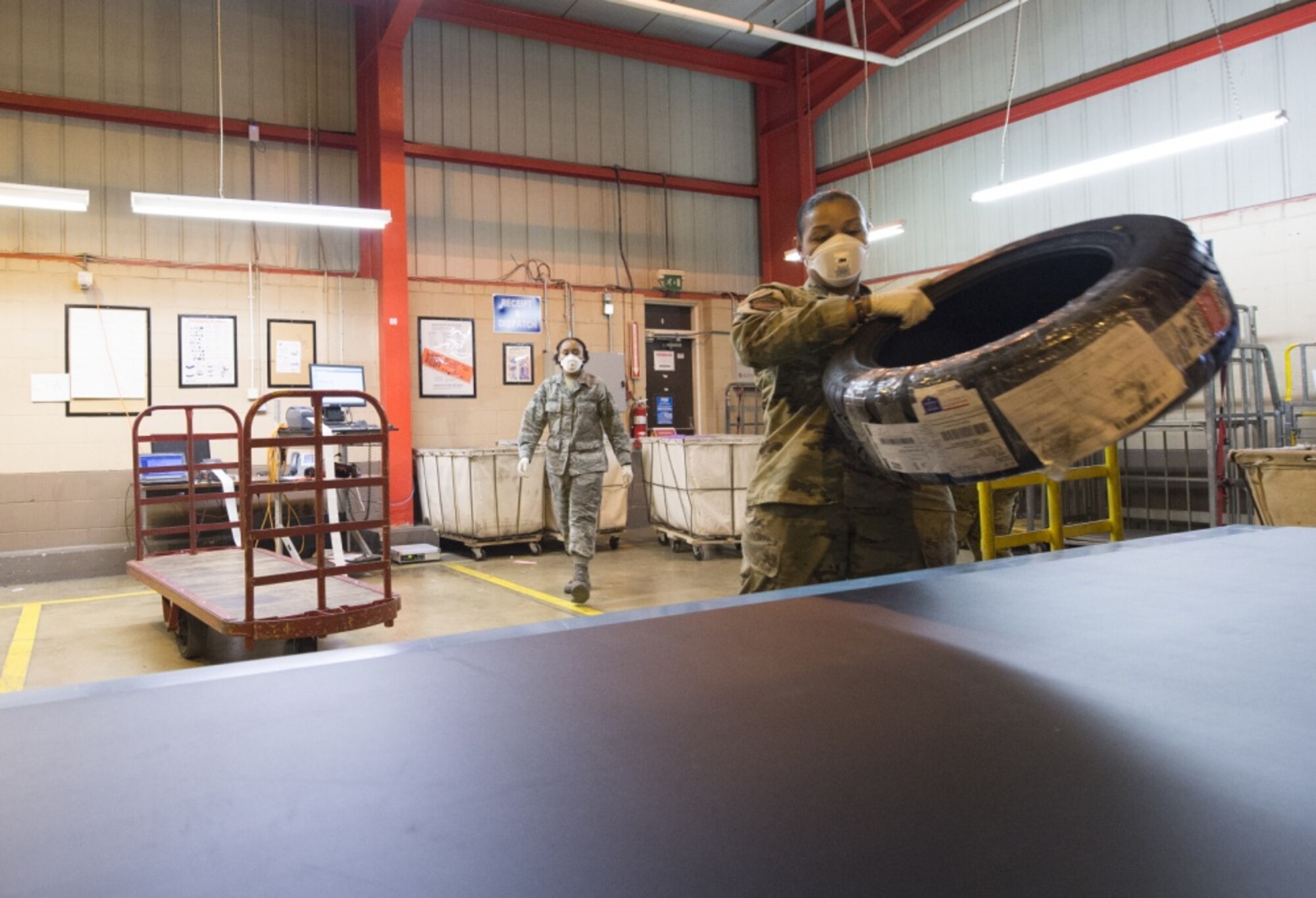 U.S. Air Force Staff Sgt. Britney White, a mail processing specialist with the USAFE-AFAFRICA Air Postal Squadron, Detachment Five, prepares a package for transport from RAF Alconbury, England on April 10, 2020. The Detachment Five postal team continue to maintain operational readiness during COVID 19 as the central postal distribution hub for U.S. service members stationed in the United Kingdom. (U.S. Air Force photo by Master Sgt. Brian Kimball)