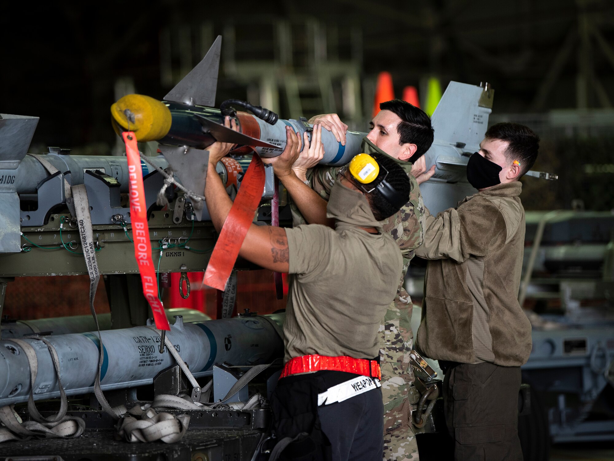 Weapons load crew Airmen assigned to the 492nd Fighter Squadron Aircraft Maintenance Unit unload munitions while wearing personal protective equipment to combat the spread of COVID-19 at Royal Air Force Lakenheath, England, April 29, 2020. Liberty Wing AMU Airmen helped the 48th Maintenance Group earn the 2019 USAFE-AFAFRICA Clements McMullen Memorial Daedalian Weapon System Maintenance Trophy. (U.S. Air Force photo by Airman 1st Class Madeline Herzog)