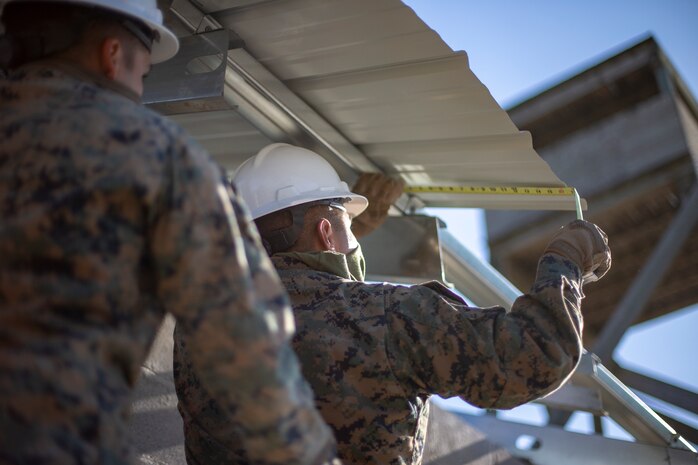 A U.S. Marine measures the overhang of a roof panel during a general exercise at Marine Corps Base Camp Lejeune, North Carolina, April 17.