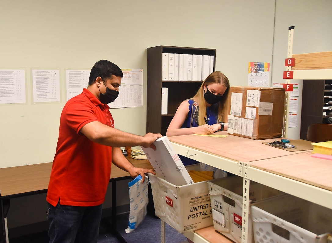 Gaya Gamage (left), and Samantha Schwoerer, U.S. Army Corps of Engineers,
Far East District mail clerks, working in mailroom at the district
headquarters, Camp Humphreys, South Korea, May 12.