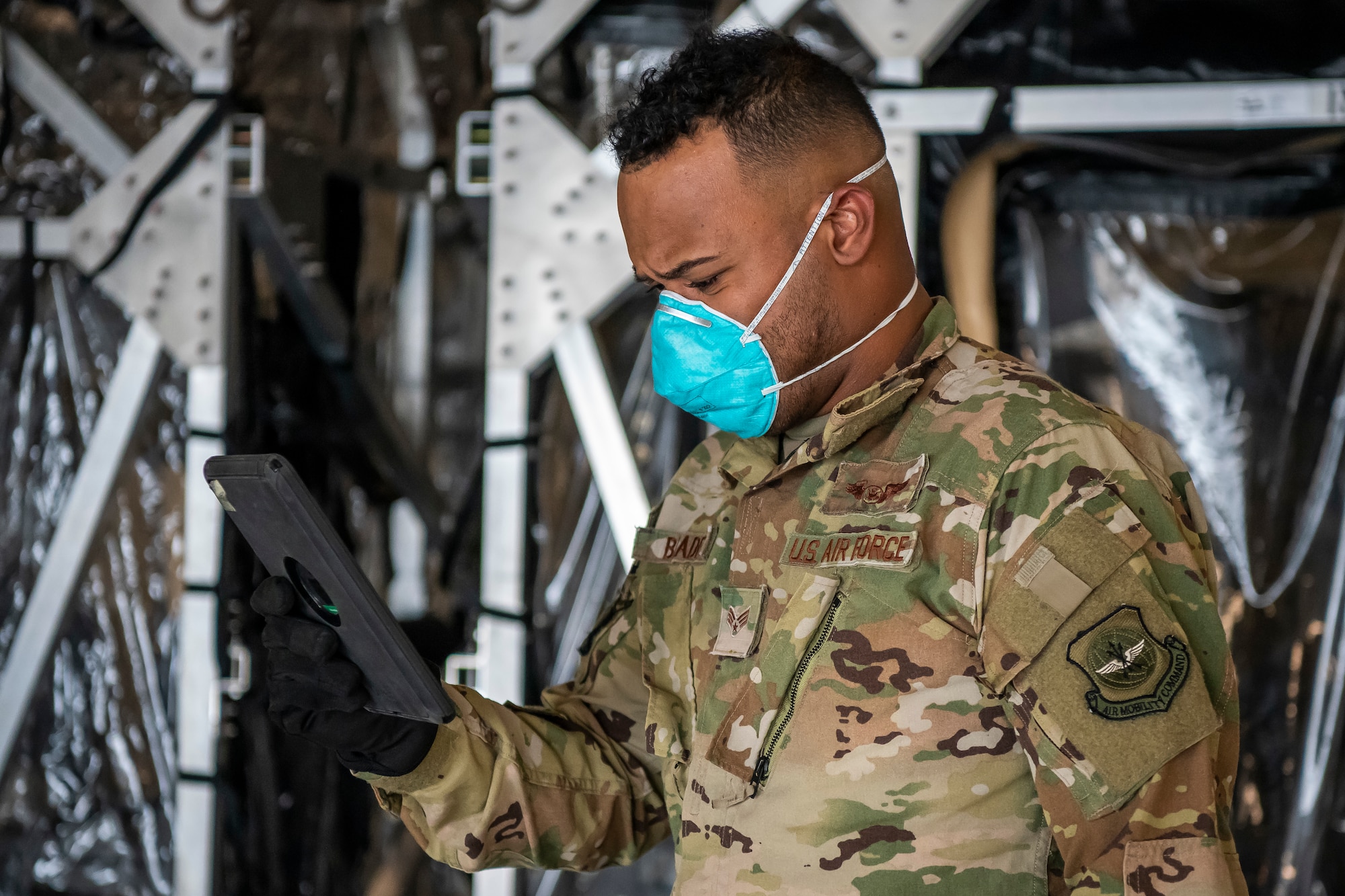 Senior Airman Jashield Blades, 16th Airlift Squadron loadmaster, reviews a checklist at Dover Air Force Base, Delaware, April 30, 2020. Two Transport Isolation Systems were delivered to Dover AFB by a C-17 Globemaster III from Joint Base Charleston, South Carolina. In accordance with health protection policies, Dover AFB will serve as the sole hub for TIS decontamination on the East Coast. (U.S. Air Force photo by Senior Airman Christopher Quail)