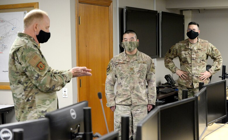 Lt. Gen. Robert D. McMurry Jr., left, commander, Air Force Life Cycle Management Center, presents an AFLCMC challenge coin to Capt. Joseph Suwabe, 88th Air Base Wing Incident Command Center financial chief at Wright-Patterson Air Force Base, Ohio, May 5, 2020. ICC personnel are monitoring the COVID-19 pandemic and McMurry was briefed on current conditions and projected trends of the disease as base leadership plans for workers to return. (U.S. Air Force photo/Ty Greenlees)