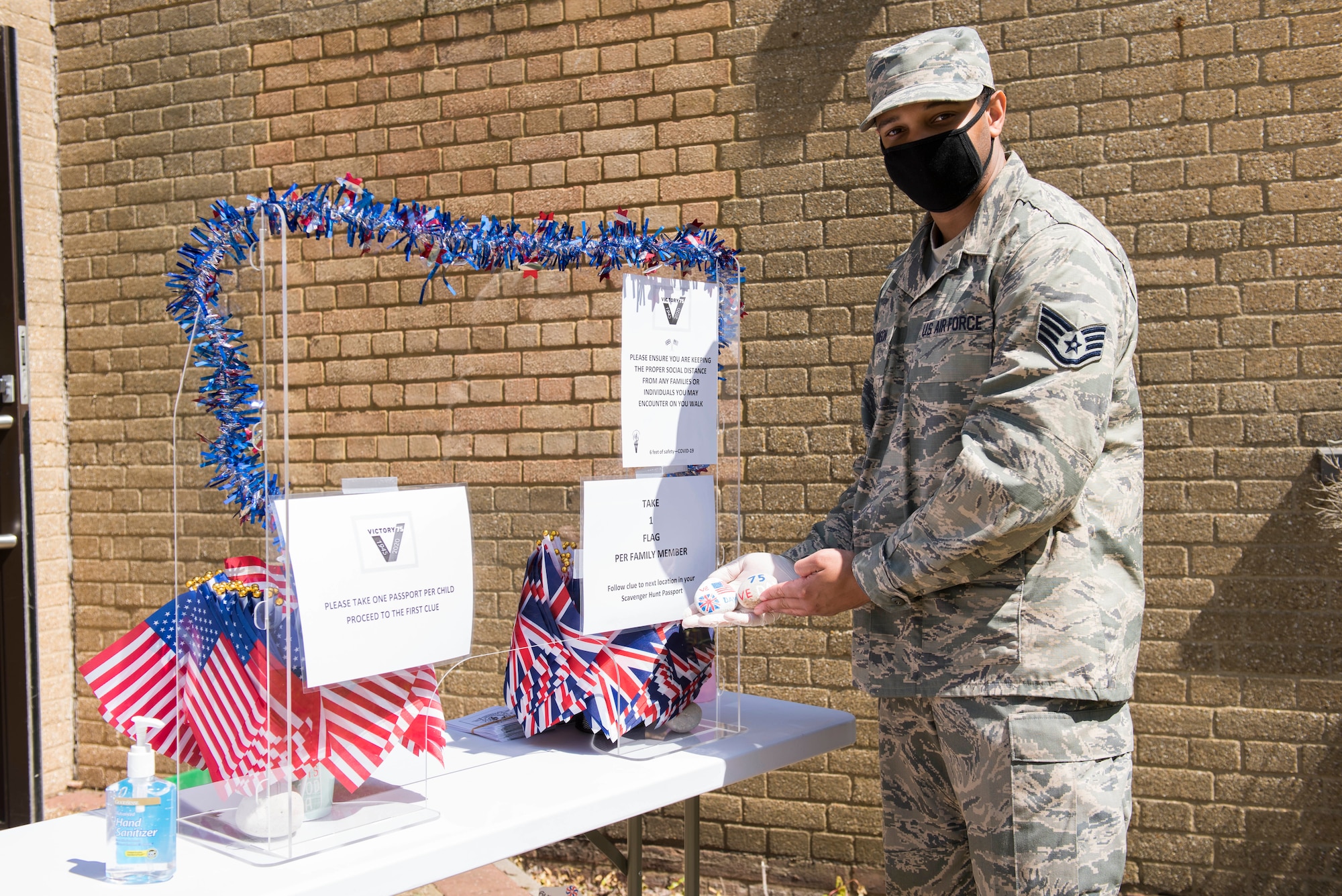 U.S. Staff Sgt. Thaddeus Johnson, 423rd Force Support Squadron Command Support Staff customer service technician, holds painted rocks  during the V-E Day Scavenger Hunt at RAF Alconbury, England May 8, 2020. While keeping with COVID-19 physical distancing guidelines, the self-guided walking tour on base was geared toward teaching children and families the events that led to the end of World War II as they exercised. (U.S. Air Force photo by Airman 1st Class Jennifer Zima)