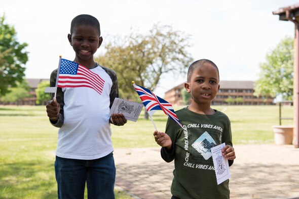 Allen and Keeghan Ransaw hold a U.S. flag and a U.K. flag during the Victory in Europe Day Scavenger Hunt at RAF Alconbury, England May 8, 2020. While keeping with COVID-19 physical distancing guidelines, the self-guided walking tour on base was geared toward teaching children and families the events that led to the end of World War II as they exercised. (U.S. Air Force photo by Airman 1st Class Jennifer Zima)