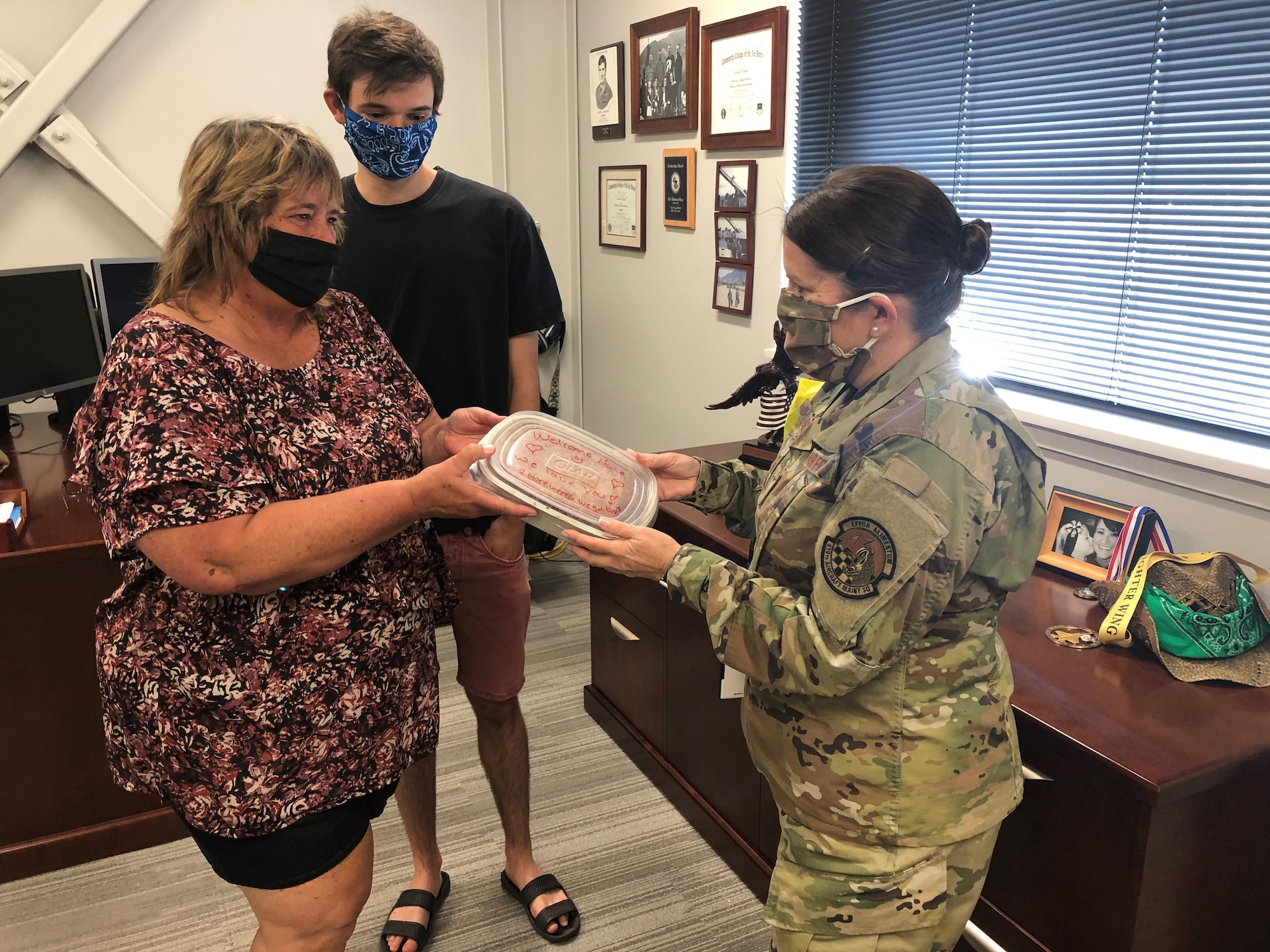 Tammy and Noah Fowler, wife and son of Chief Master Sgt. Craig Fowler, pass a homemade cake to Senior Master Sgt. Tamara Wass, the first sergeant for the 419th Aircraft Maintenance Squadron.