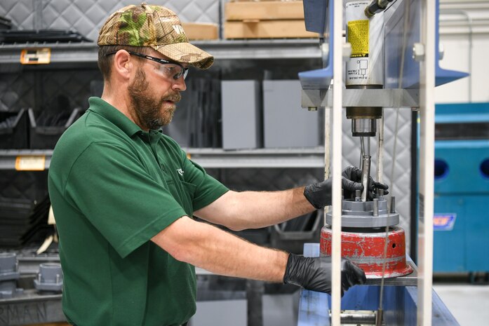 Tommy Cook, 309th Electronics Maintenance Group, presses out races on a rear hub of a MH-2 bomb lift April 29, 2020, at Hill Air Force Base, Utah. The 309th EMXG in the Ogden Air Logistics Complex provides repair and overhaul for exchangeable assets for a multitude of systems on a wide assortment of Air Force weapons systems including fighter aircraft, intercontinental ballistic missiles, powered aerospace ground equipment, tactical shelters, as well as refurbishment of radomes worldwide. (U.S. Air Force photo by Cynthia Griggs)