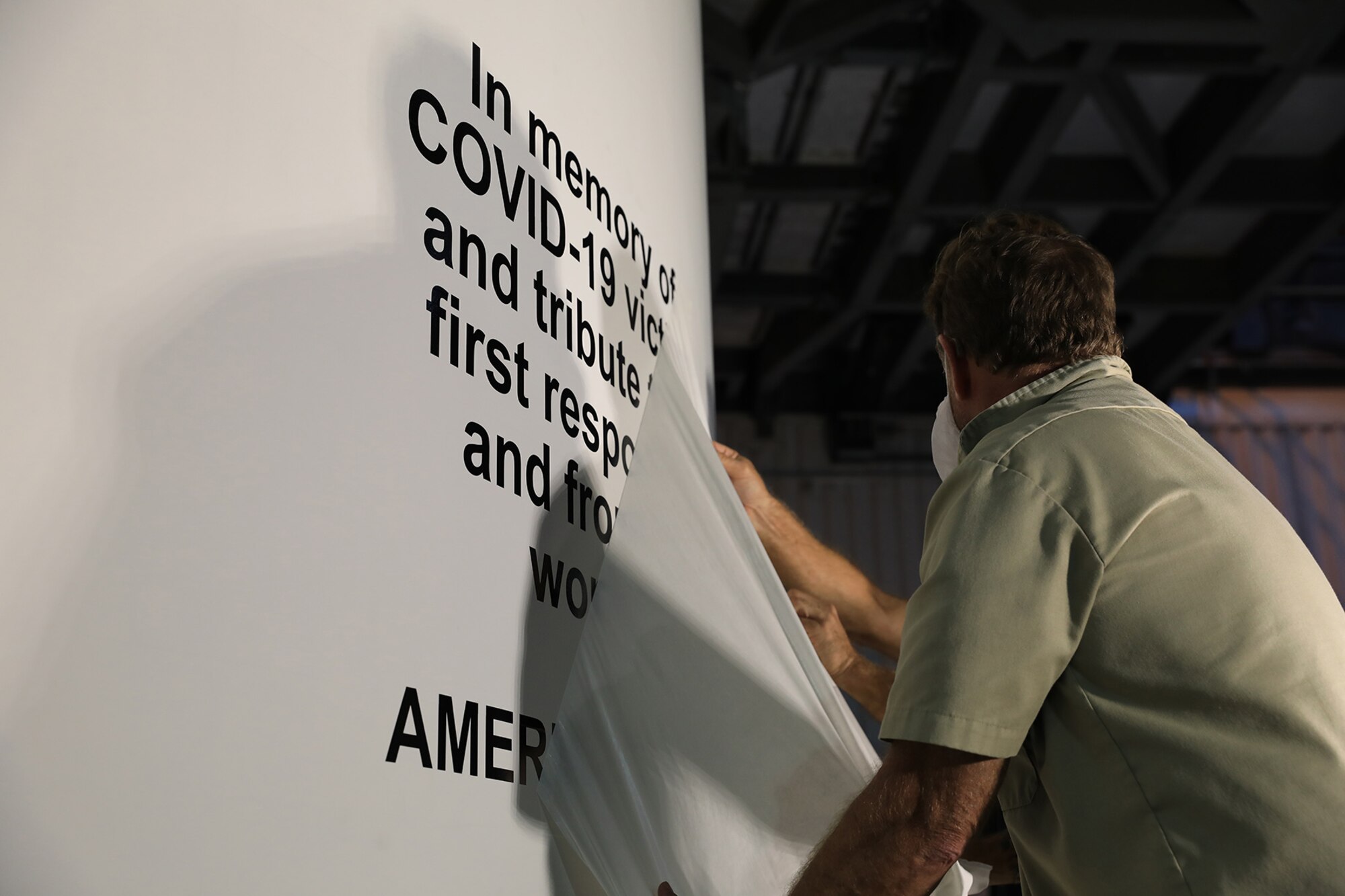 United Launch Alliance staff members apply a special dedication "In memory of COVID-19 victims and tribute to all first responders and front-line workers" March 11, 2020, on the payload fairing of an Atlas V rocket that will launch the X-37B Orbital Test Vehicle for the U.S. Space Force and U.S. Air Force at Cape Canaveral Air Force Station, Florida.