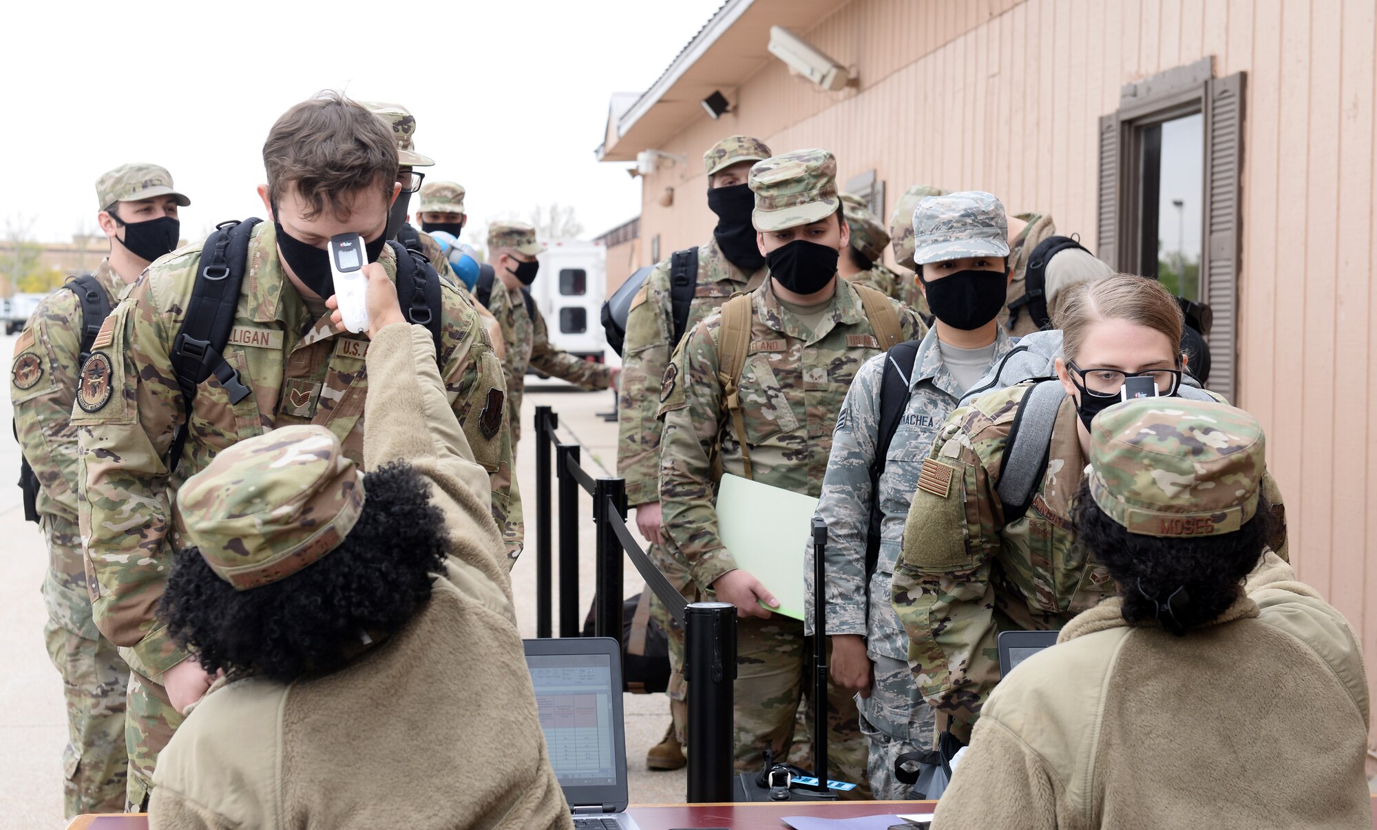 women taking temperatures of military members
