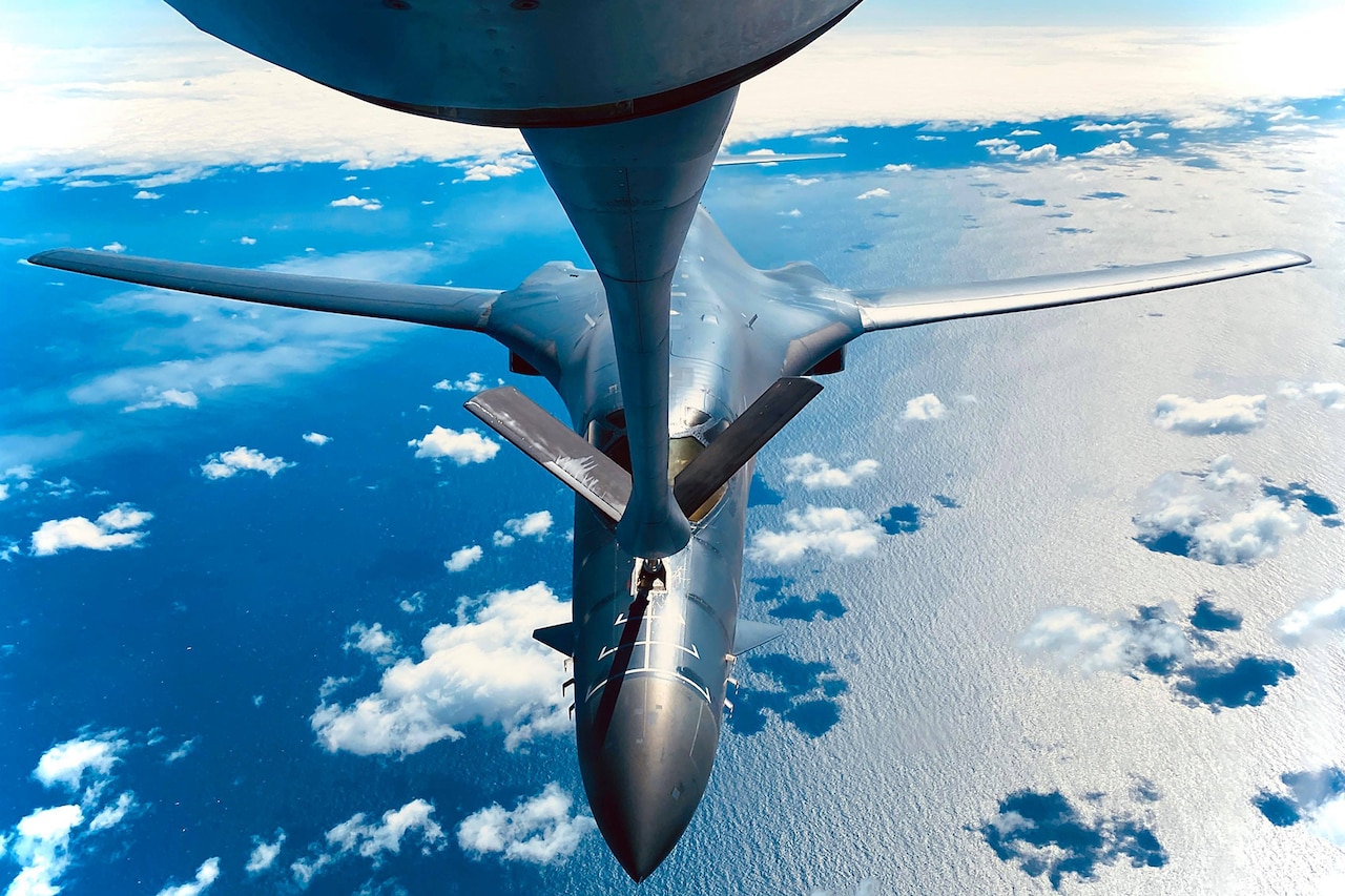 A military aircraft is refueled in midair.