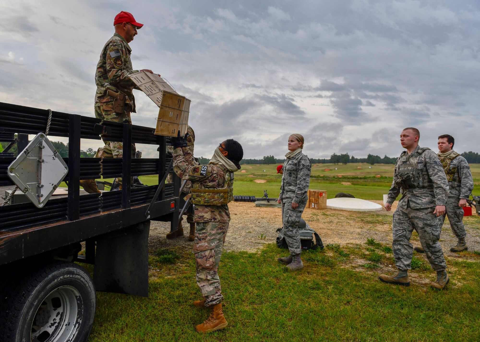 Airmen from the 4th Security Forces Squadron unload gear from a pickup truck at a range on Fort Bragg, N.C., May 6, 2020. Prior to firing at the range Airmen and instructor’s setup training stations with a mat, wooden ammo collection box, tool box, an M249 light machine gun, an extra barrel and 200-round ammunition boxes. (U.S. Air Force photo by Airman First Class Kimberly Barrera)