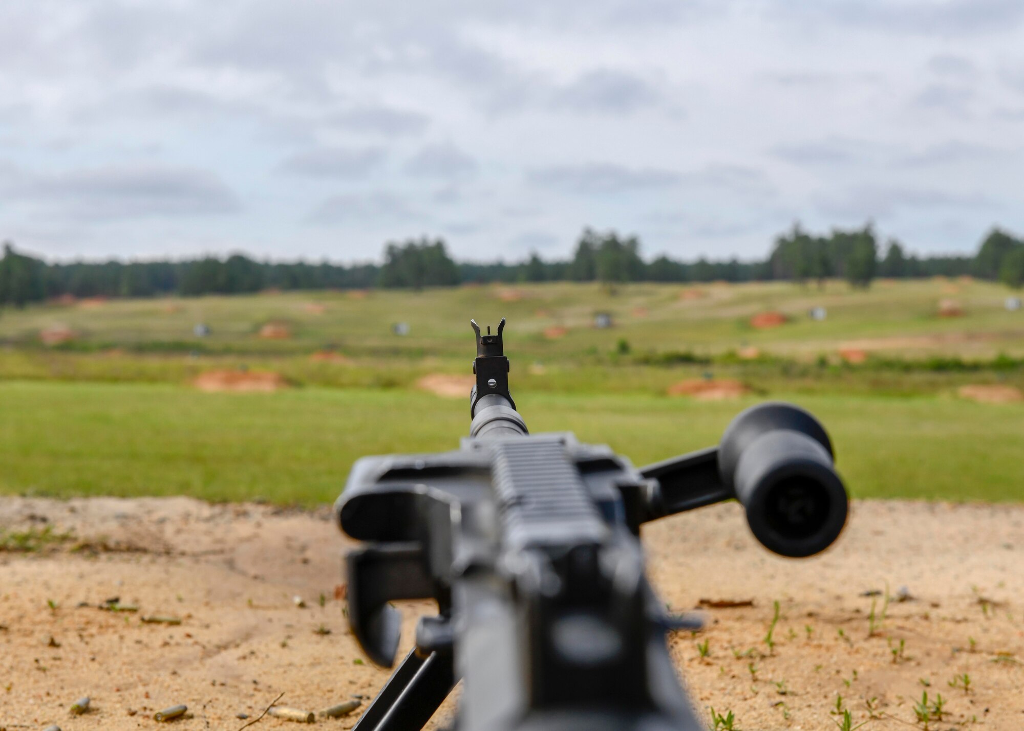 An M249 light machine gun is aimed toward a machine gun full distance range at Fort Bragg, North Carolina, May 6, 2020. The M249 engages point targets out to 800 meters with a maximum rate of fire of 850 rounds per minute. (U.S. Air Force photo by Airman First Class Kimberly Barrera)