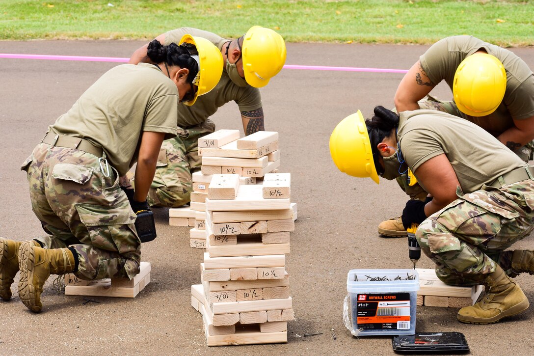 Soldiers wearing protective gear build platforms.