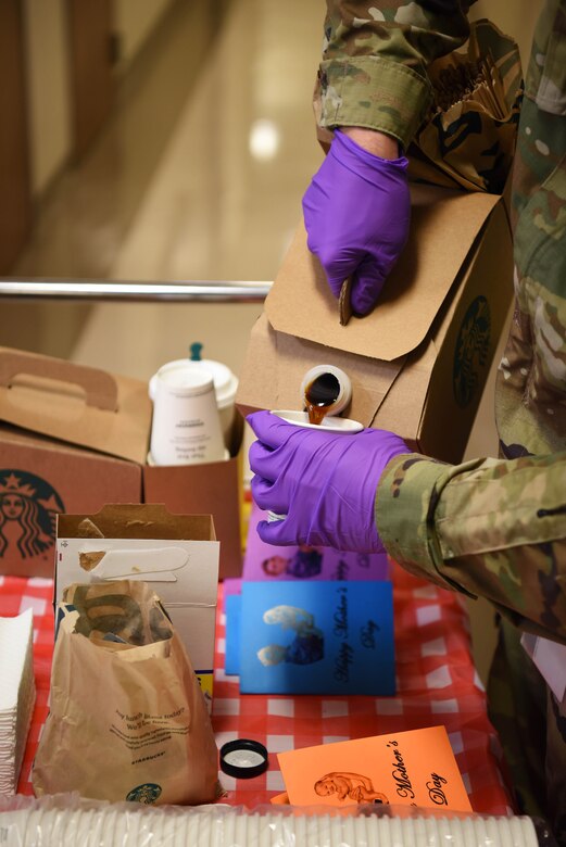 Staff Sgt. George Mills (right), 14th Operational Medical Readiness Squadron Public Health Flight non-commissioned officer in-charge, pours coffee into a cup May 8, 2020, inside the Koritz Clinic on Columbus Air Force Base, Miss. This walk-through also celebrated Mother’s Day as the volunteers took the time to find mothers who work at the 14th Medical Group to give them special made cards to honor them and all that they do. (U.S. Air Force photo by Airman 1st Class Jake Jacobsen)