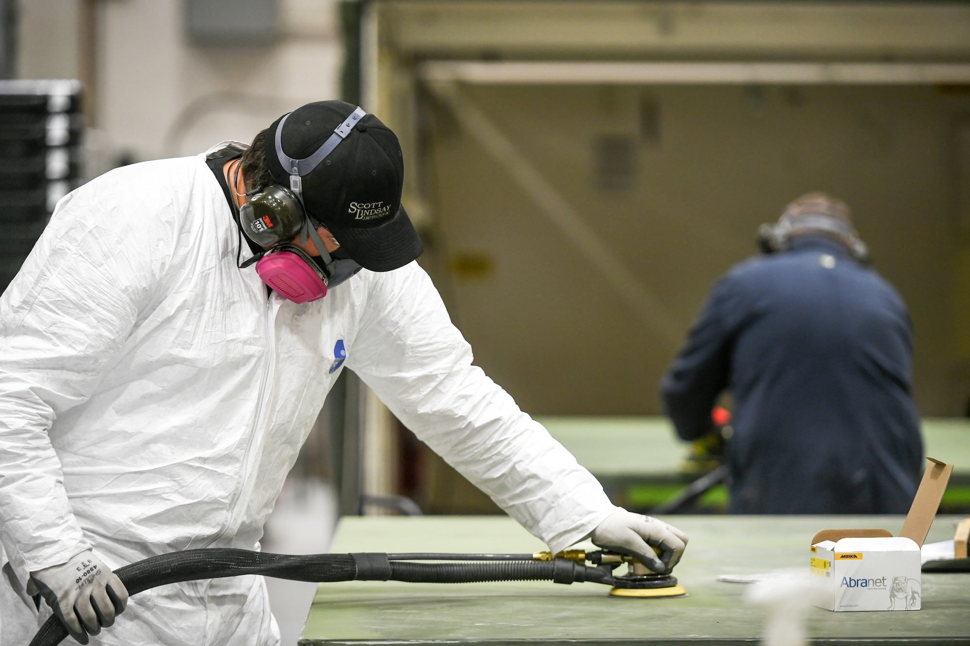 Two workers in the 309th Electronics Maintenance Group sand out walls for a tactical shelter April 29, 2020, at Hill Air Force Base, Utah. The 309th EMXG in the Ogden Air Logistics Complex provides repair and overhaul for exchangeable assets for a multitude of systems on a wide assortment of Air Force weapons systems including fighter aircraft, intercontinental ballistic missiles, powered aerospace ground equipment, tactical shelters, as well as refurbishment of radomes worldwide. (U.S. Air Force photo by Cynthia Griggs)
