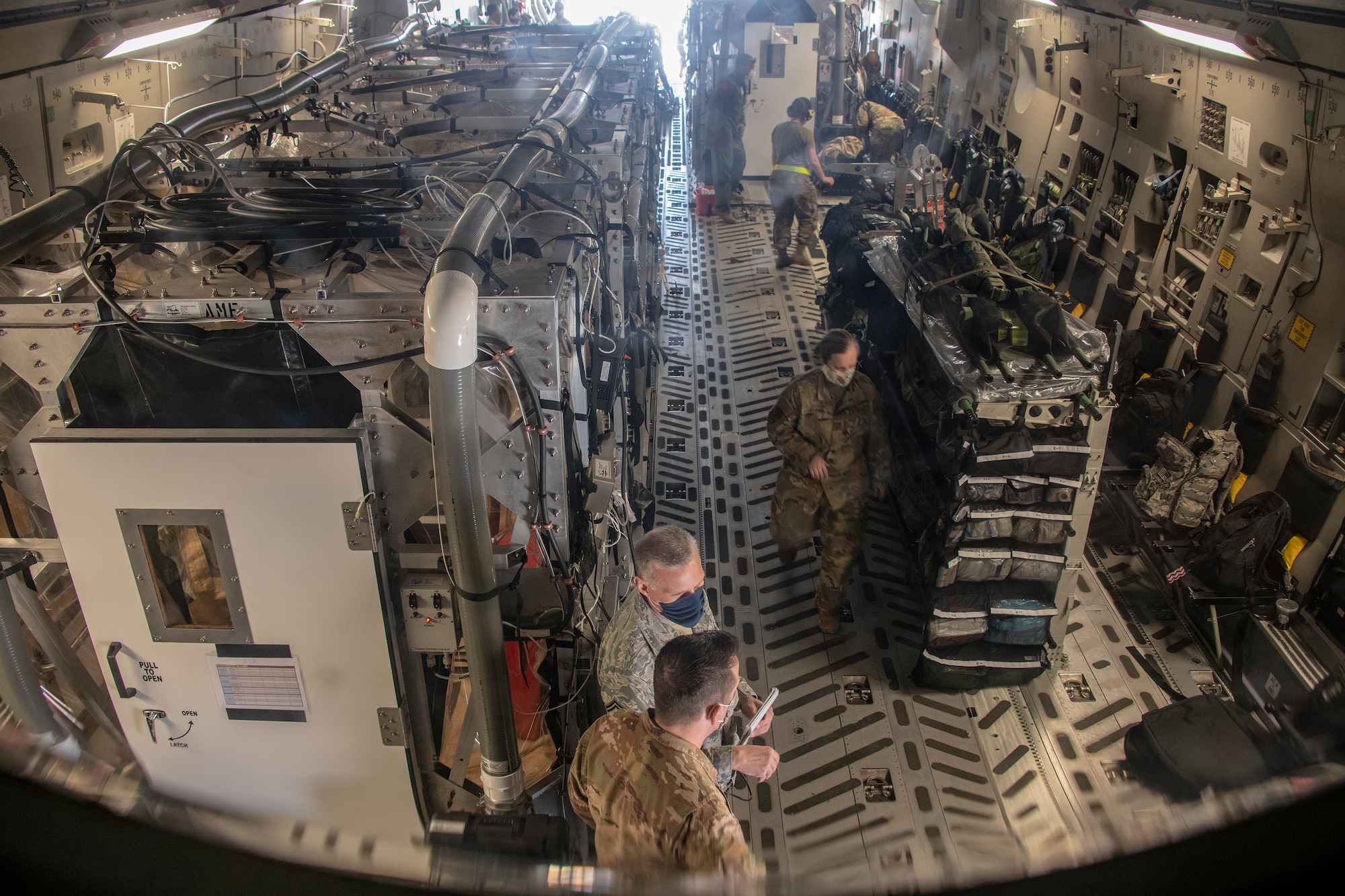 Two Transport Isolation System capsules sit in the cargo bay of a C-17 Globemaster III May 7, 2020, at Travis Air Force Base, California. TIS capsules, which the DOD initially engineered in response to the Ebola virus in 2014, allow the transport of individuals with highly contagious diseases without infecting other passengers or aircrew on the aircraft. (U.S. Air Force photo by Heide Couch)
