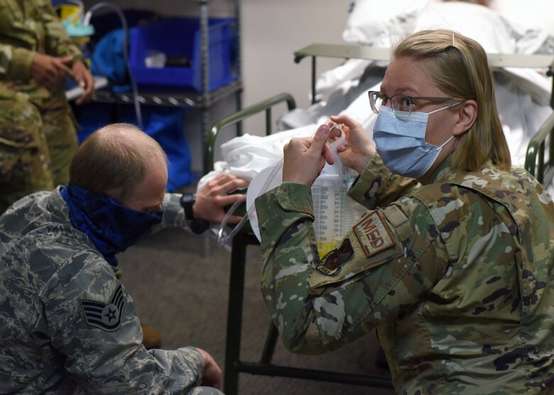Staff Sgt. Nicholas DiCesare, 460th Medical Group medical technician (left), and Senior Airman Kristina Balog, 460th Medical Group medical technician (right), examine a catheter bag during a medical simulation at the Human Performance Center on Buckley Air Force Base, Colo., May 6, 2020. The 460th Medical Group personnel participated in simulation training scenarios to brush up on their inpatient skills in case they have to provide support for COVID-19 elsewhere.  (U.S. Air Force photo by Airman 1st Class Haley N. Blevins)