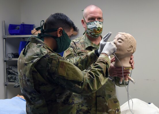 Staff Sgt. Nicholas DiCesare, 460th Medical Group medical technician (left), and Senior Airman Kristina Balog, 460th Medical Group medical technician (right), examine a catheter bag during a medical simulation at the Human Performance Center on Buckley Air Force Base, Colo., May 6, 2020. The 460th Medical Group personnel participated in simulation training scenarios to brush up on their inpatient skills in case they have to provide support for COVID-19 elsewhere.  (U.S. Air Force photo by Airman 1st Class Haley N. Blevins)