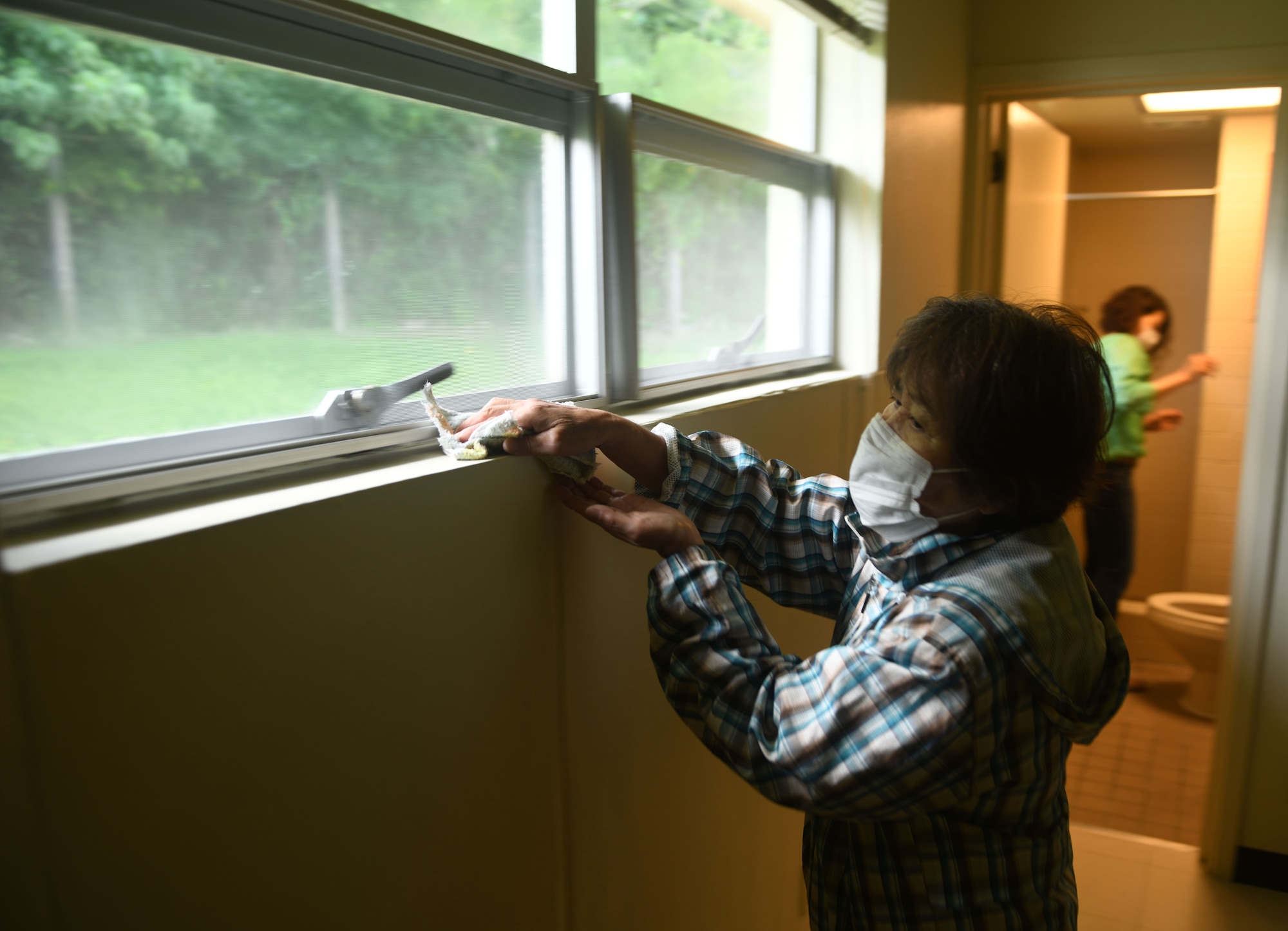 Employee cleaning windowsill.