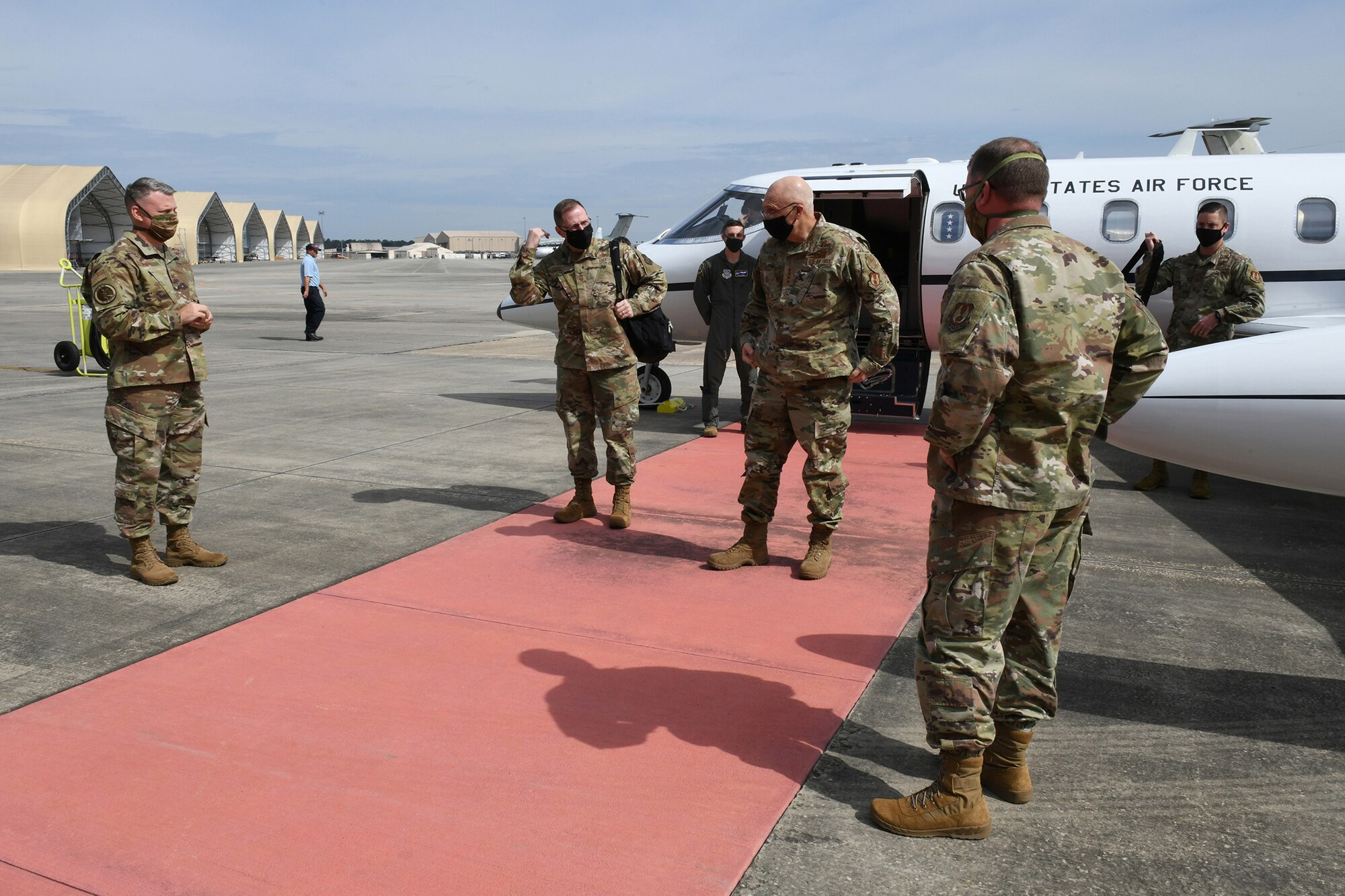 Photo shows Bunch debarking his plane with Robins leadership greeting him from a safe distance.