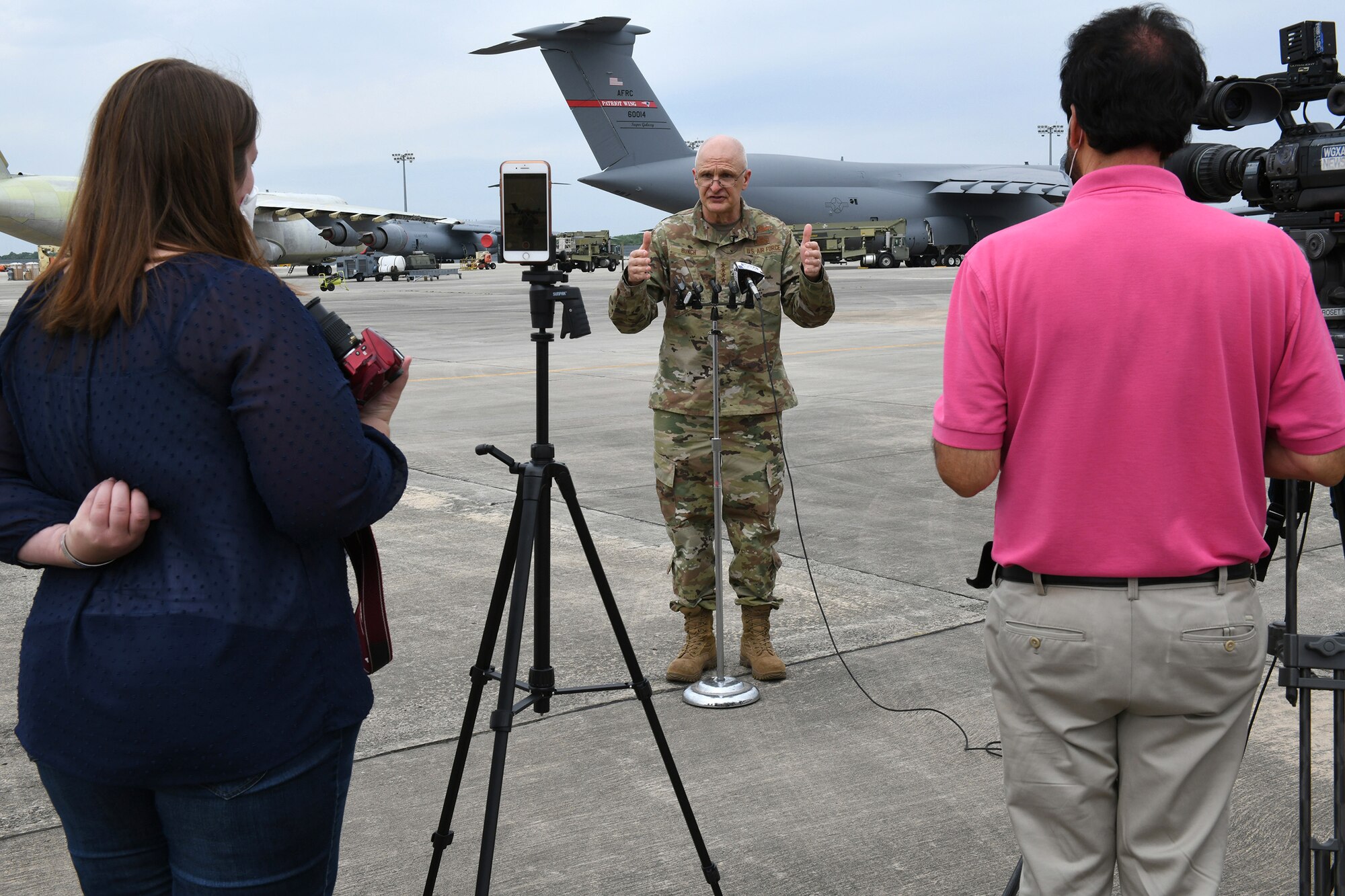 Photo shows Bunch speaking to two media members with their cameras out.