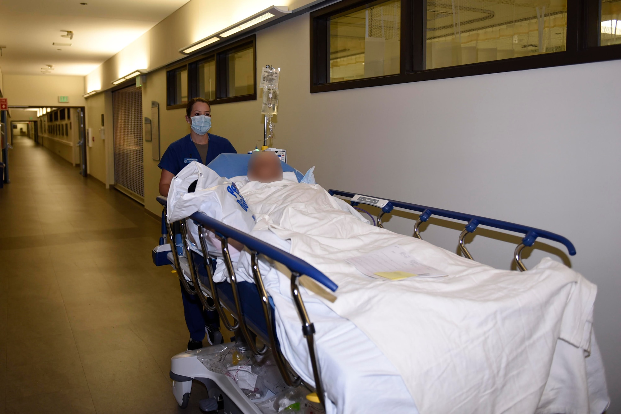 U.S. Air Force 1st Lt. Mariah Pruett, 60th Medical Operations Squadron clinical nurse, pushes a patient on a stretcher May 5, 2020, at Travis Air Force Base California. May 6-12 is National Nurse Week, a week that celebrates medical professionals, like Pruett, who are on the frontlines of patient-centered care every day. (Air Force photo by Airman 1st Class Cameron Otte)