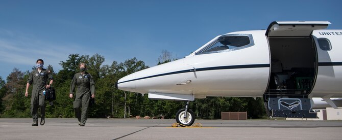 U.S. Air Force Capt. Taylor Stephens, 76th Airlift Squadron readiness flight commander, and 1st Lt. Jacob Goodwin, 76th AS training officer, walk out to a C-21A Learjet at Ramstein Air Base, Germany, May 8, 2020.