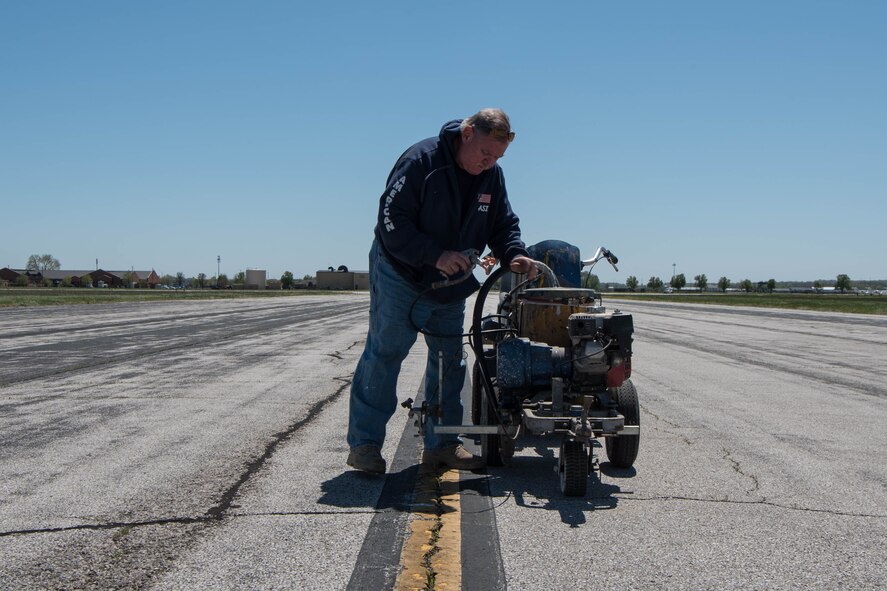 Man checking tubes of painting tool/vehicle.