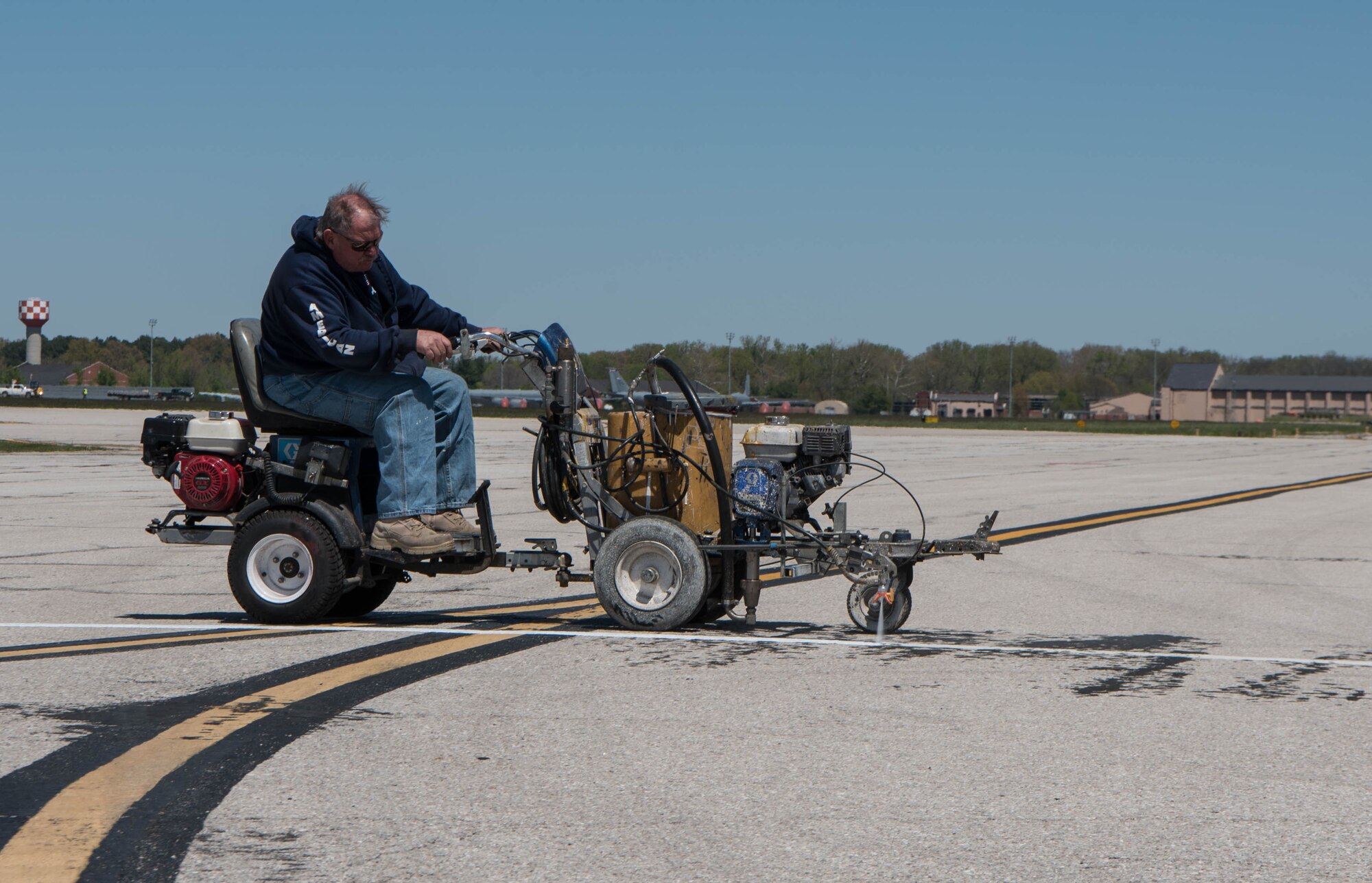 Man in painting vehicle, painting flightline.