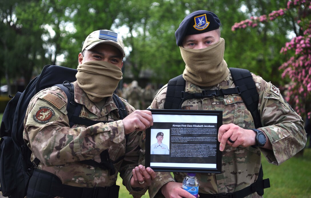 Airmen from the 100th Security Forces Squadron hold a photo of Airman 1st Class Elizabeth Jacobson during the 100th SFS Memorial Ruck March during National Police Week at RAF Mildenhall, England, May 13, 2020. Jacobson was killed in 2005 while deployed to Iraq and was the first female U.S. Airman killed in the line of duty in support of Operation Iraqi Freedom, and the first Air Force Security Forces member killed in conflict since the Vietnam War. (U.S. Air Force photo by Senior Airman Brandon Esau)