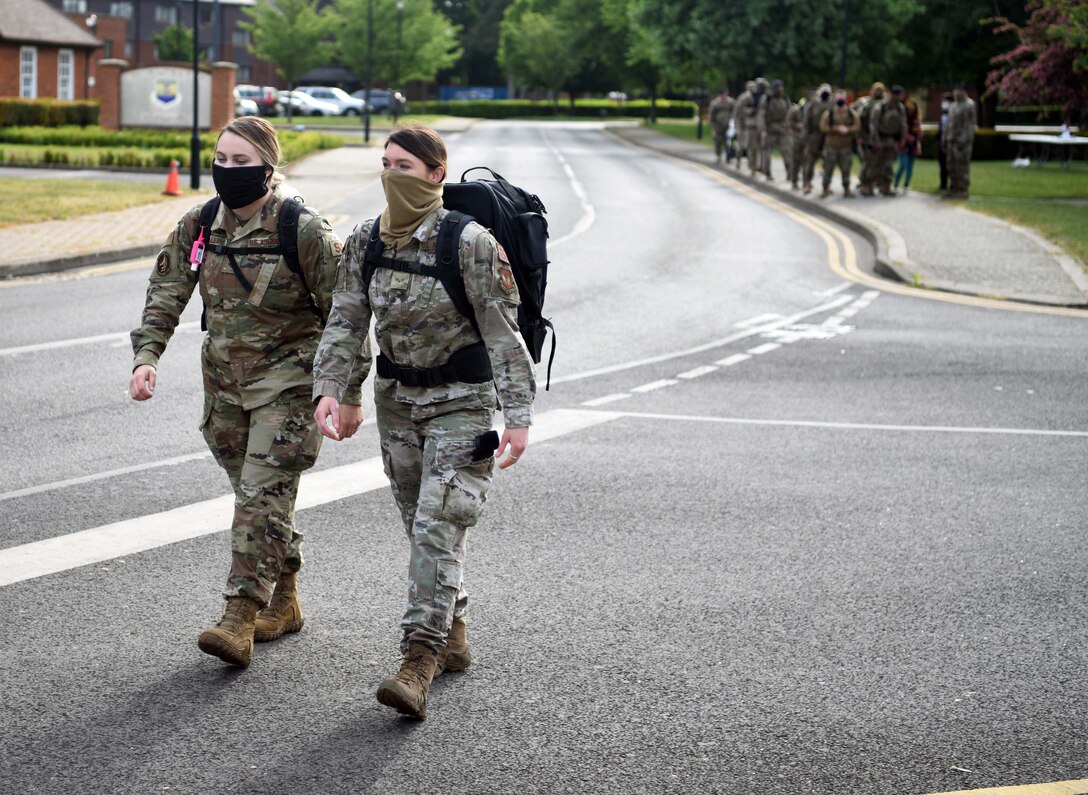 While practicing physical distancing, Airmen from the 100th Security Forces Squadron march during the 100th SFS Memorial Ruck March to commemorate National Police Week at RAF Mildenhall, England, May 13, 2020. National Police Week is an observance in the United States which pays tribute to local, state and federal officers who’ve died or who’ve been disabled in the line of duty. (U.S. Air Force photo by Senior Airman Brandon Esau)