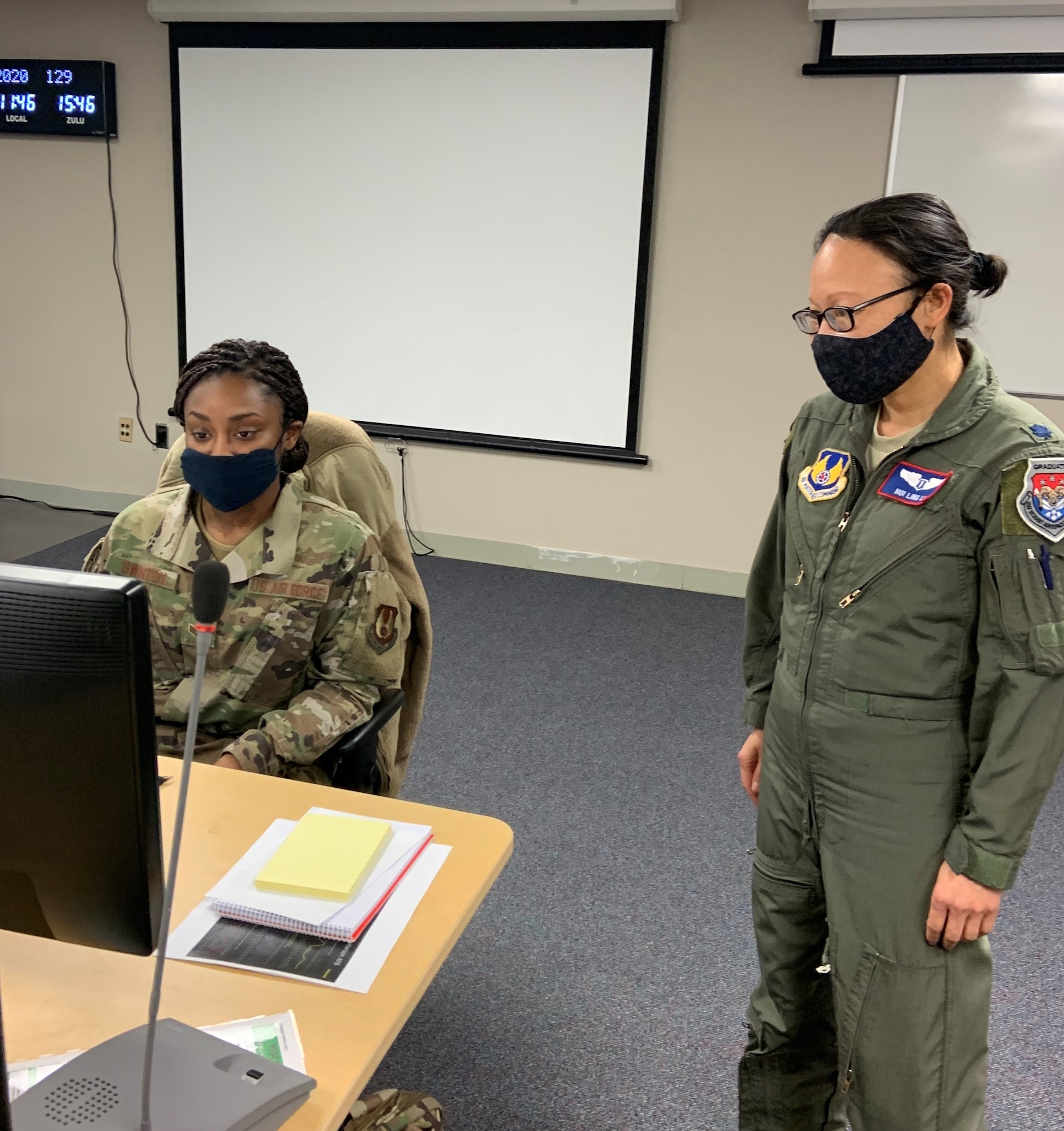 Col. Hui Li, 88th Medical Group’s Chief of Aerospace Medicine, 88th Air Base Wing Public Health Emergency Officer and Wright-Patt AFB COVID-19 incident commander, talks with ICC administrative support Senior Airman Quaniesha Swinton, while working in the incident control center. (U.S. Air Force photo/Stacey Geiger)