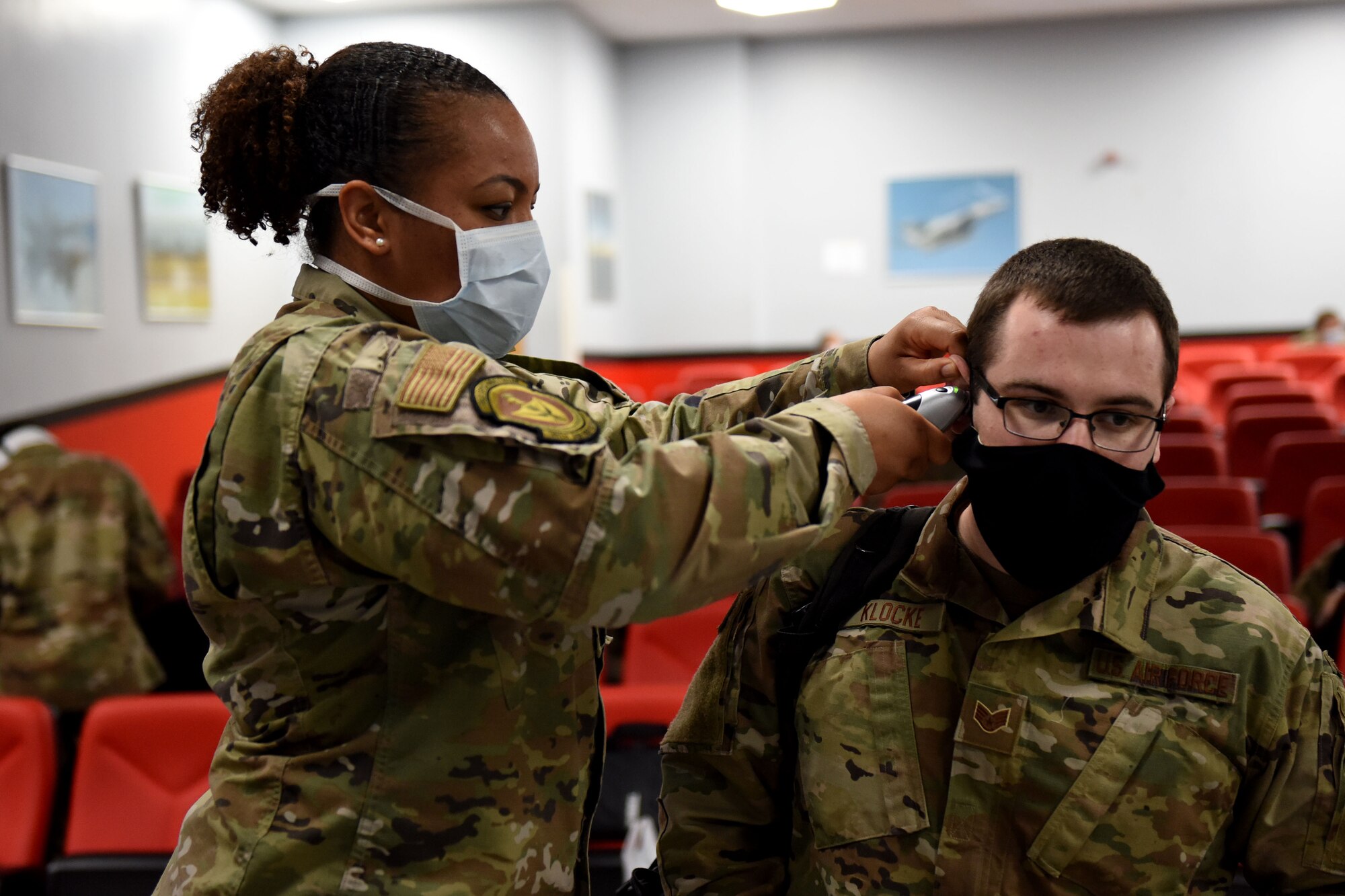 A 48th Medical Group Airman checks the temperature of an Airman assigned to the 492nd Fighter Squadron while completing pre-deployment line tasks at Royal Air Force Lakenheath, England, May 6, 2020. The 492nd FS is the first fighter squadron from the Liberty Wing to deploy since the start of the COVID-19 pandemic. (U.S. Air Force photo by Senior Airman Christopher S. Sparks)