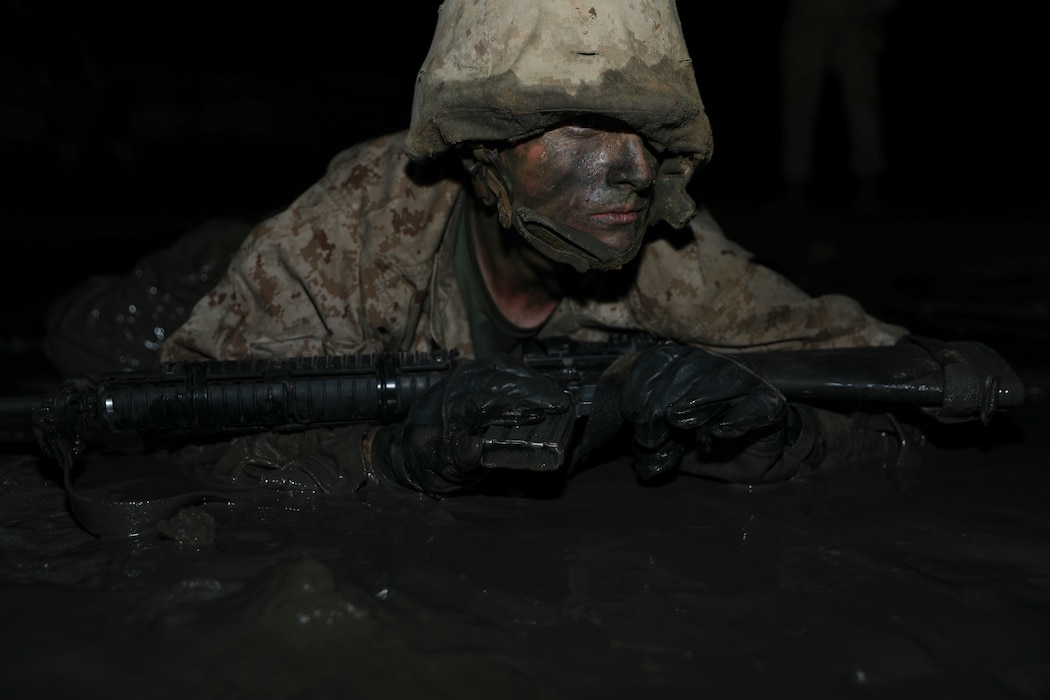 A recruit with Charlie Company, 1st Recruit Training Battalion, advances in a simulated battle during the Crucible aboard Marine Corps Depot Parris Island, Mar. 26, 2020. The Crucible is a 54-hour culminating event that requires recruits to work as a unit to overcome challenges.(U.S. Marine Corps photo by Lance Cpl. Ryan Hageali)