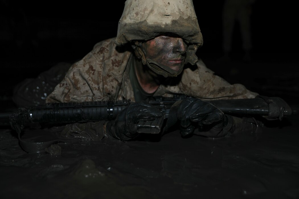 A recruit with Charlie Company, 1st Recruit Training Battalion, advances in a simulated battle during the Crucible aboard Marine Corps Depot Parris Island, Mar. 26, 2020. The Crucible is a 54-hour culminating event that requires recruits to work as a unit to overcome challenges.(U.S. Marine Corps photo by Lance Cpl. Ryan Hageali)